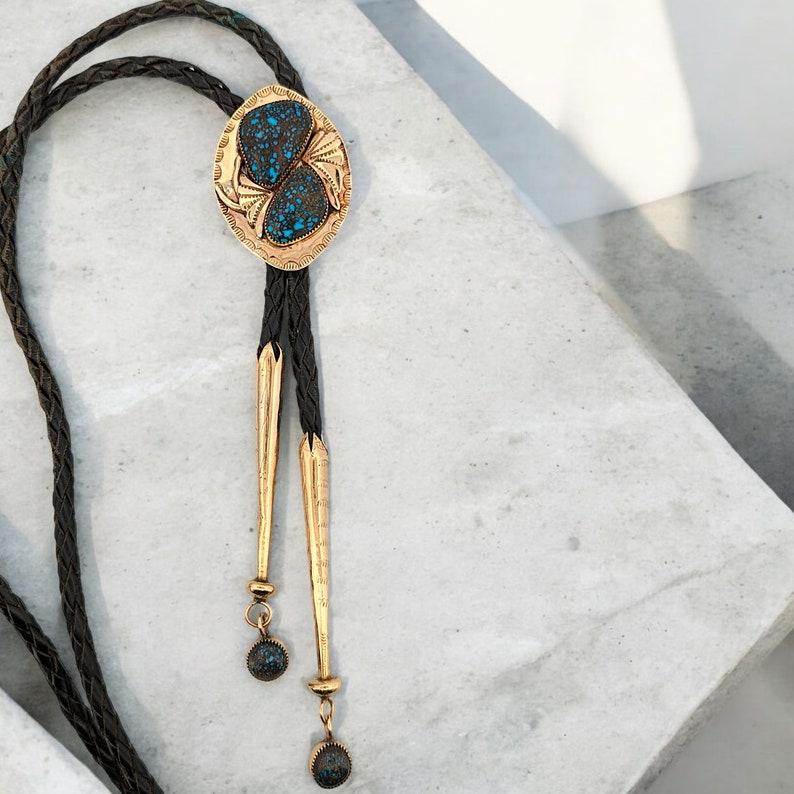 Vintage 14k Gold Handmade Rare Lander Blue Turquoise Bolo Tie - Original Paperwork Included. This one of a kind beauty features 14k bolo and ends, but the true find in this is the Lander Blue turquoise. Less than 110 lbs of Lander Blue were mined