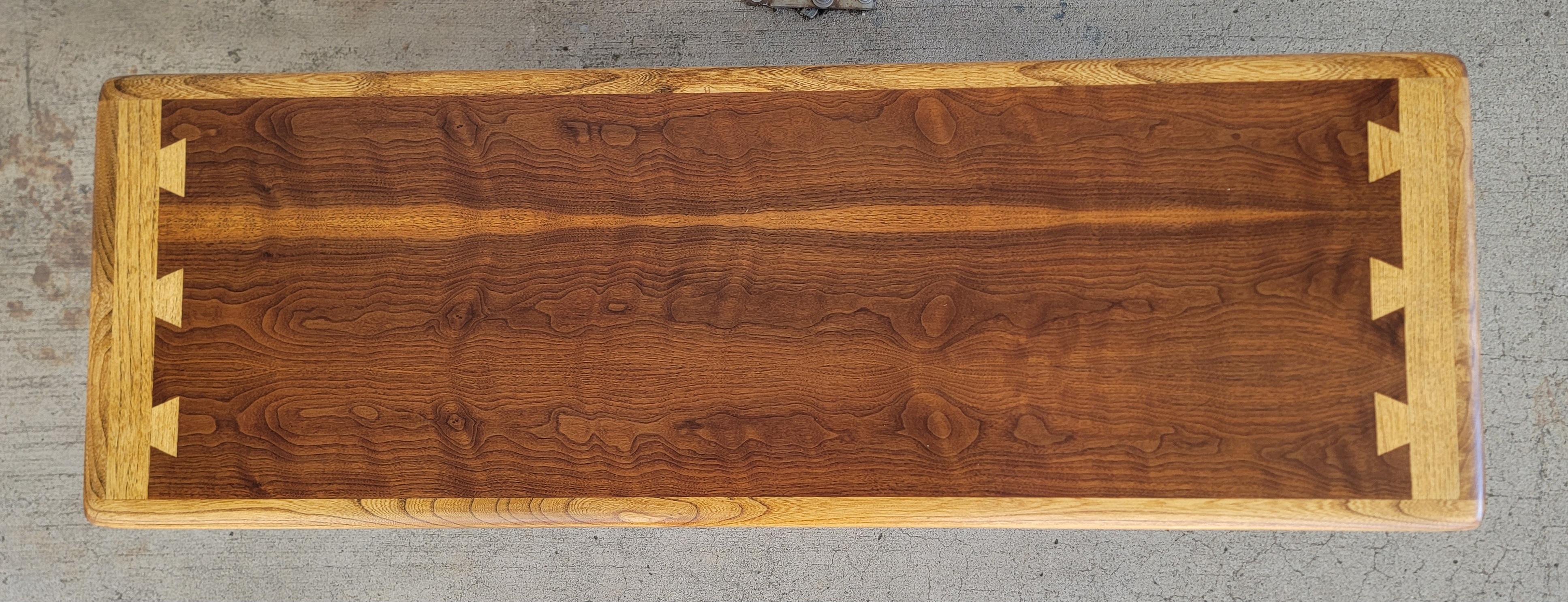 A Mid-Century Modern rectangular coffee table designed by Andre Bus for Lane Furniture Company. Circa. 1960's. Dovetail detail to top surface, tapered legs. Very nice wood grain to top surface. Table made of walnut, dovetail in oak. Refinished.

56