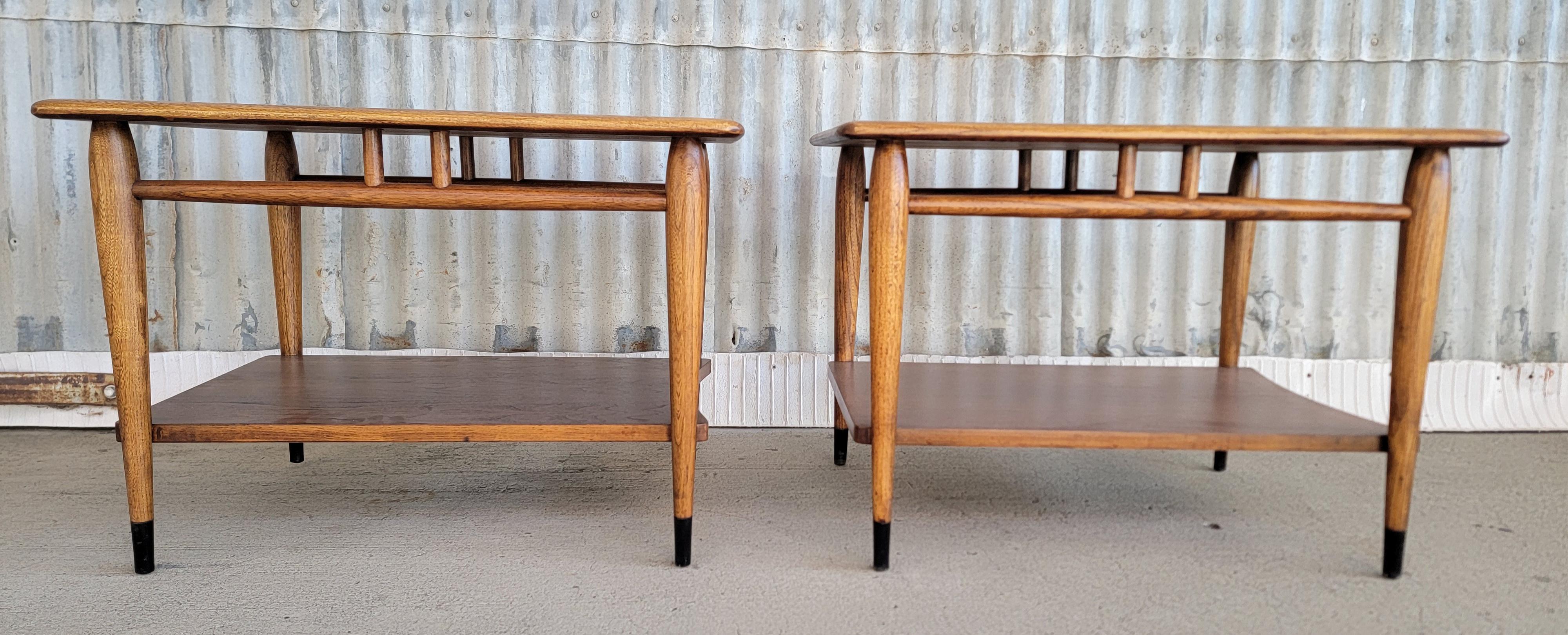 A Mid-Century Modern pair of rectangular end tables designed by Andre Bus for Lane Furniture Company. Circa. 1960's. Dovetail detail to top surface, tapered legs. Very nice wood grain to top surface. Tables made of walnut, dovetail in oak.