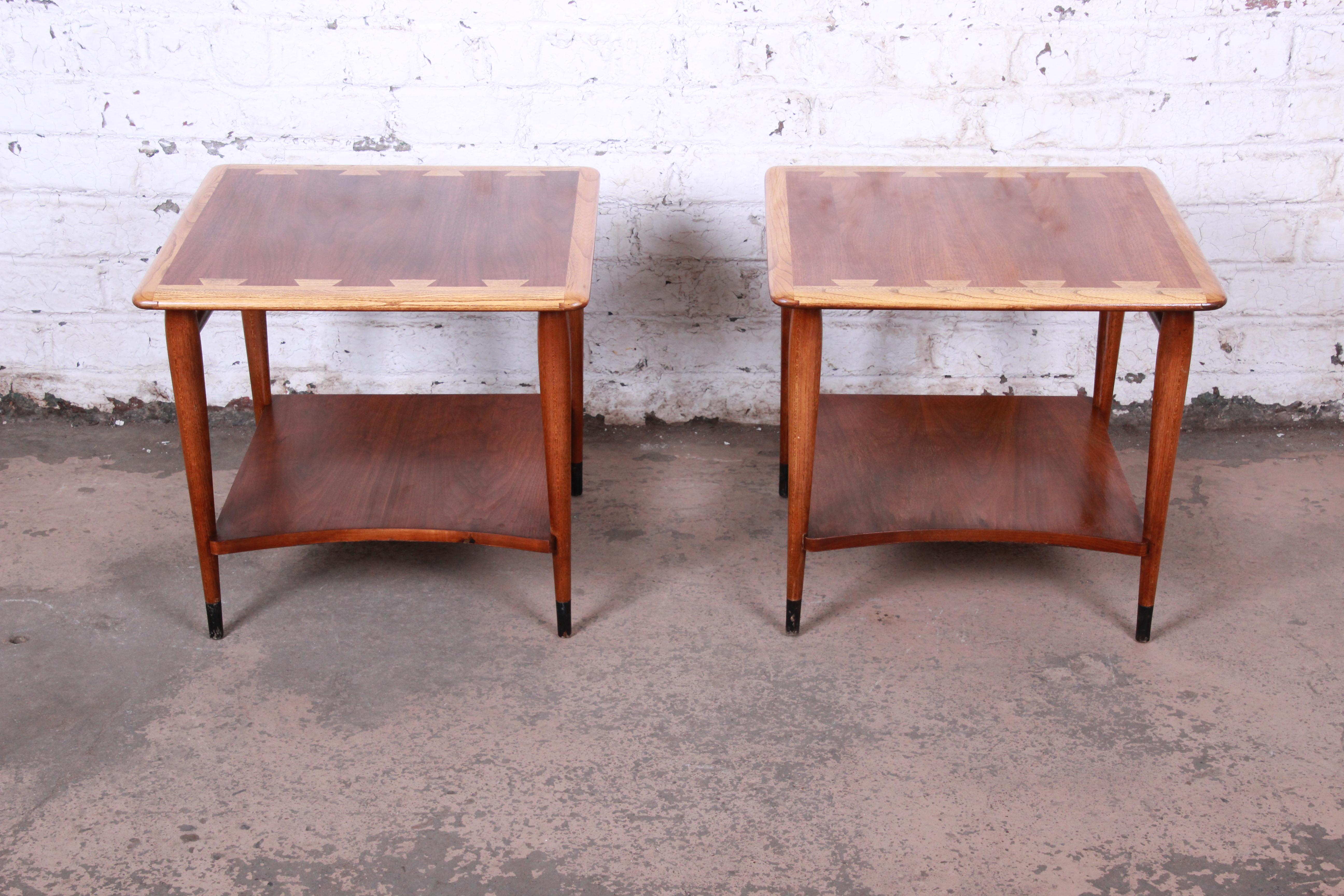 A beautiful pair of Mid-Century Modern side tables from the Acclaim line by Lane. The tables features gorgeous walnut wood grain with the iconic ash dovetails. They have sculpted solid walnut legs and stretchers and ebonized feet. The original