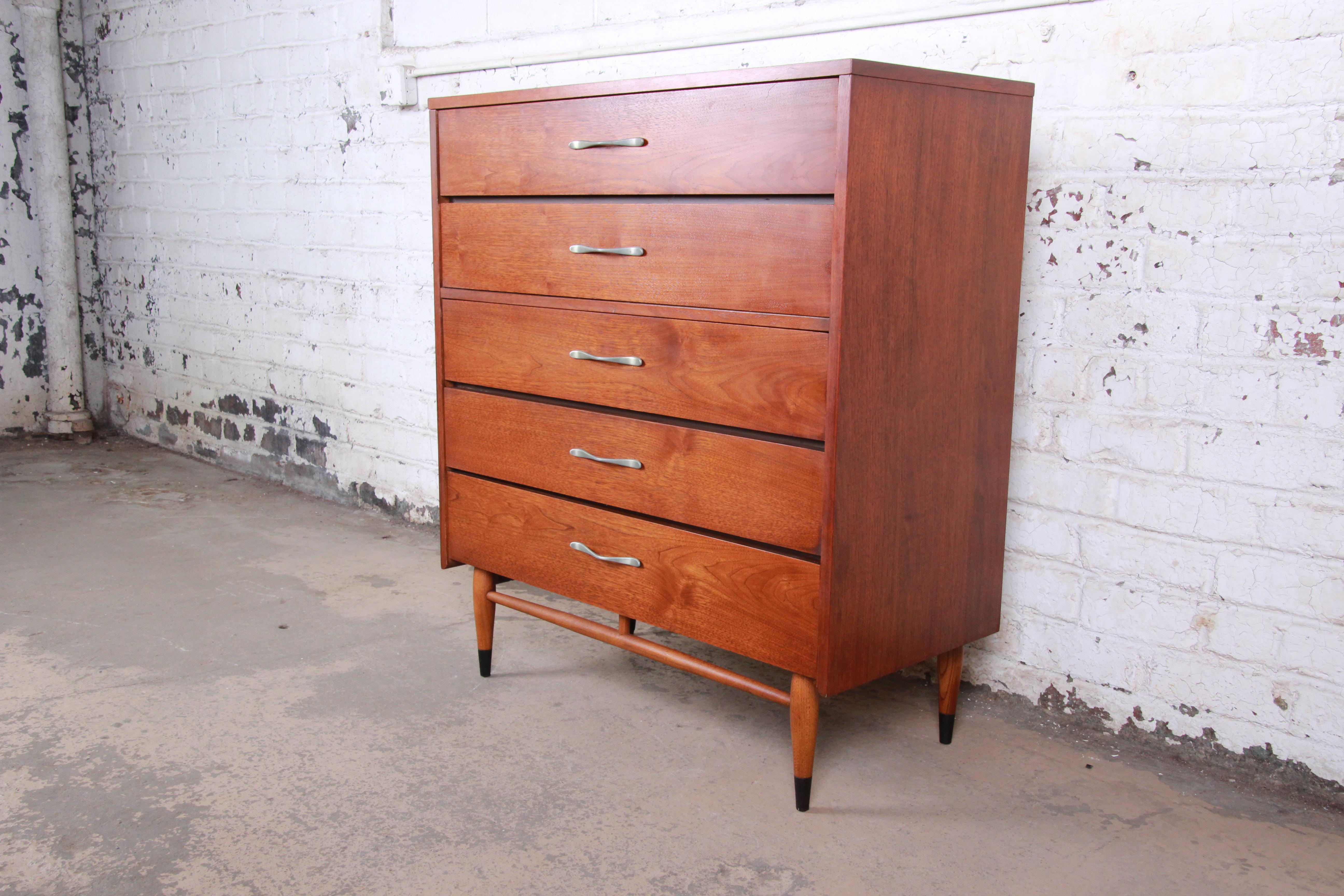 A gorgeous mid-century modern walnut and ash highboy dresser from the Acclaim line by Lane. The dresser features the signature ash dovetails, polished aluminum drawer pulls, and sleek mid-century design. It offers ample storage, with five dovetailed