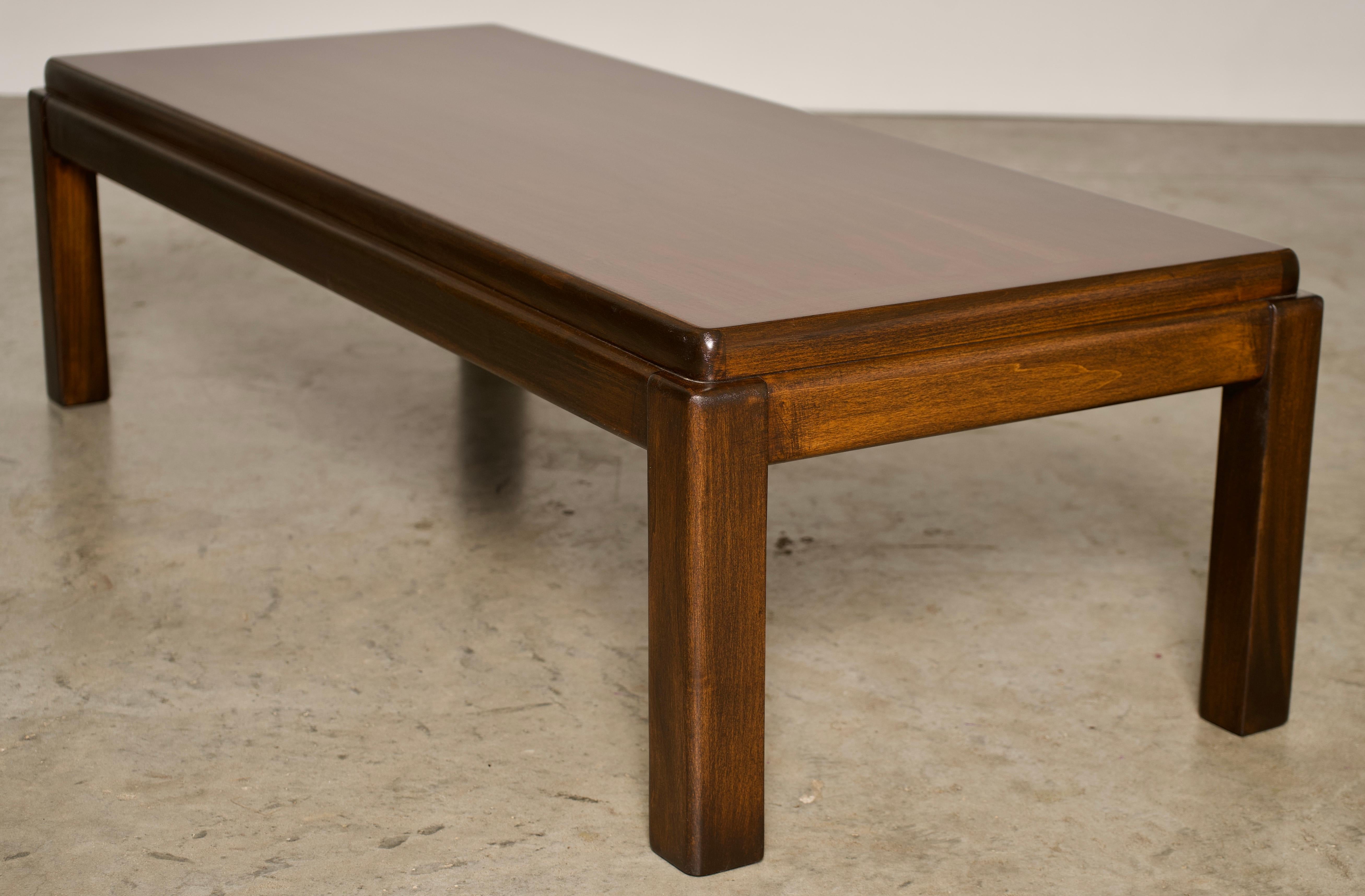 An American walnut rectangular coffee table made by Lane. This Mid-Century Modern coffee table in walnut was made in Altavista, VA by Lane Furniture, manufacturer from the early 1960s. It features simple, geometric lines and a sleek low profile. The