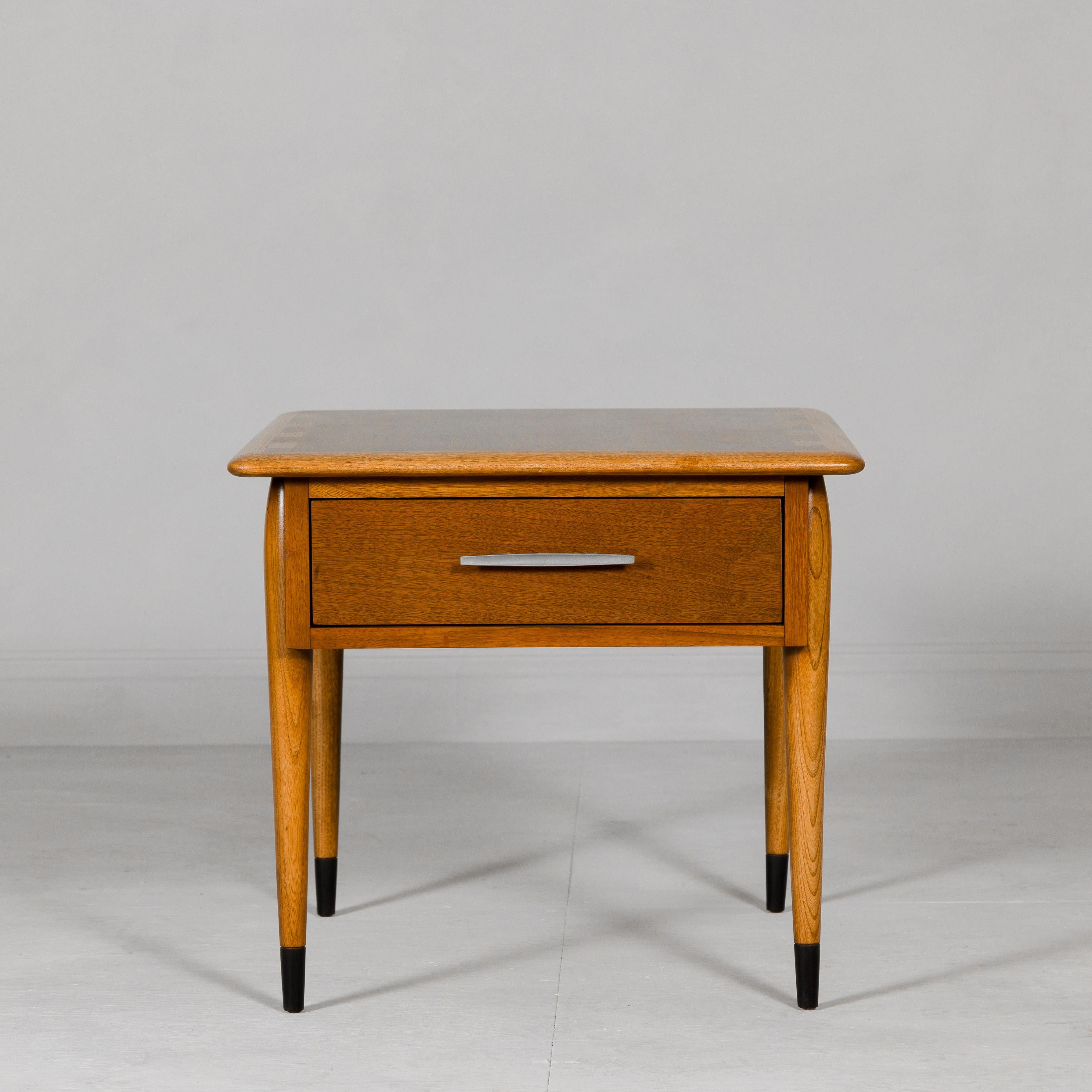 A Lane Altavista Midcentury side table with single drawer and tapering legs. This Lane Altavista Midcentury side table is a superb example of the timeless allure of midcentury modern design. Its elegant simplicity, characterized by clean lines and a
