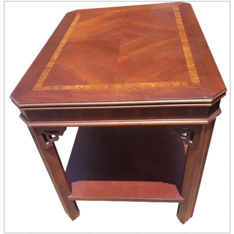 Beautiful vintage Chippendale style mahogany side table by Lane, featuring banded and bookmatched rectangular top with lovely fretwork adorns the corners raised on carved straight legs joined by a lower shelf. From the mid 20th century. Approximate