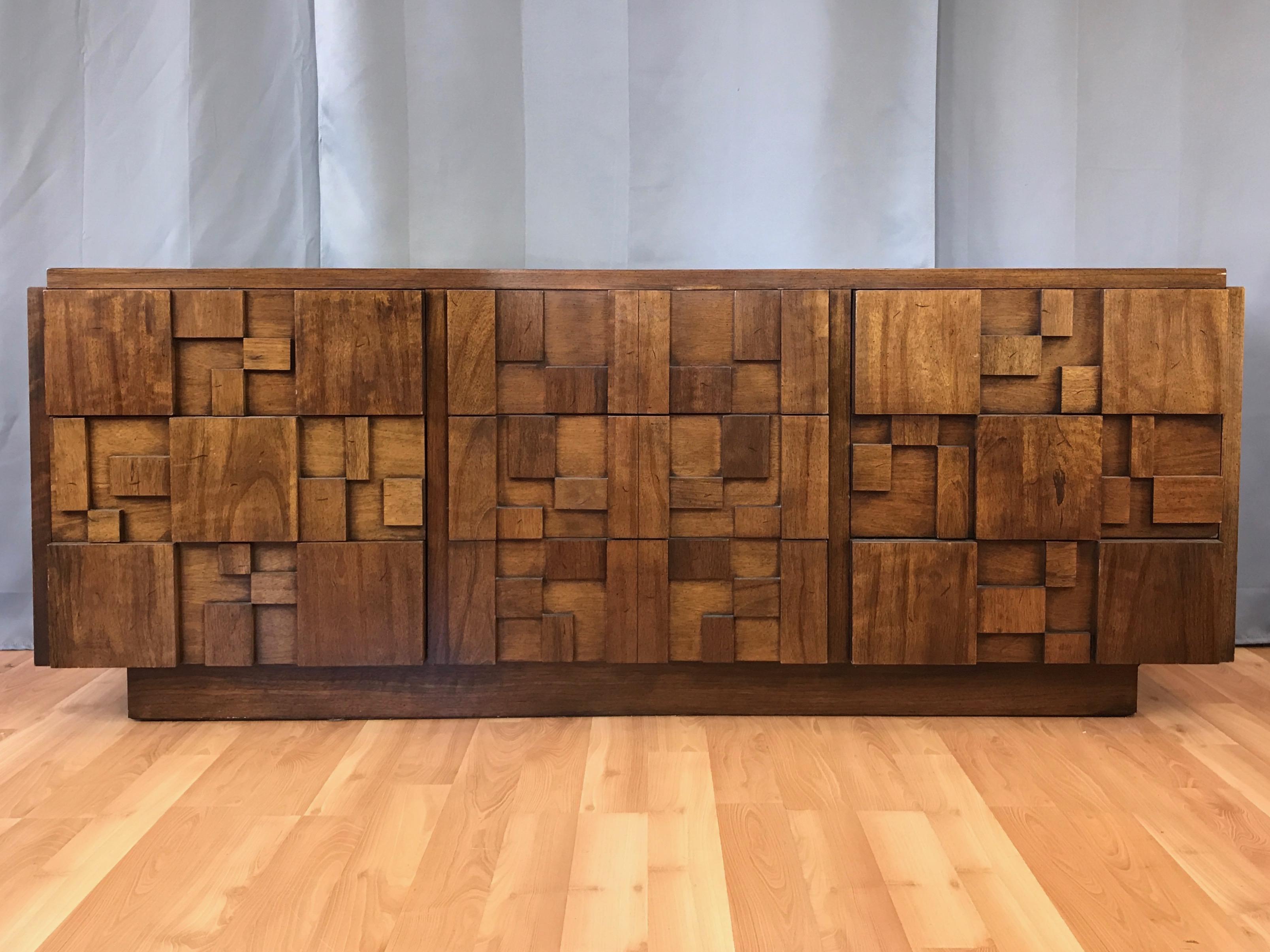A very substantial Brutalist walnut nine-drawer dresser from Lane’s Mosaic collection.

Shares the blocky architectural aesthetic of Paul Evan’s contemporaneous Cityscape collection, with geometric elements of varied thickness that reveal