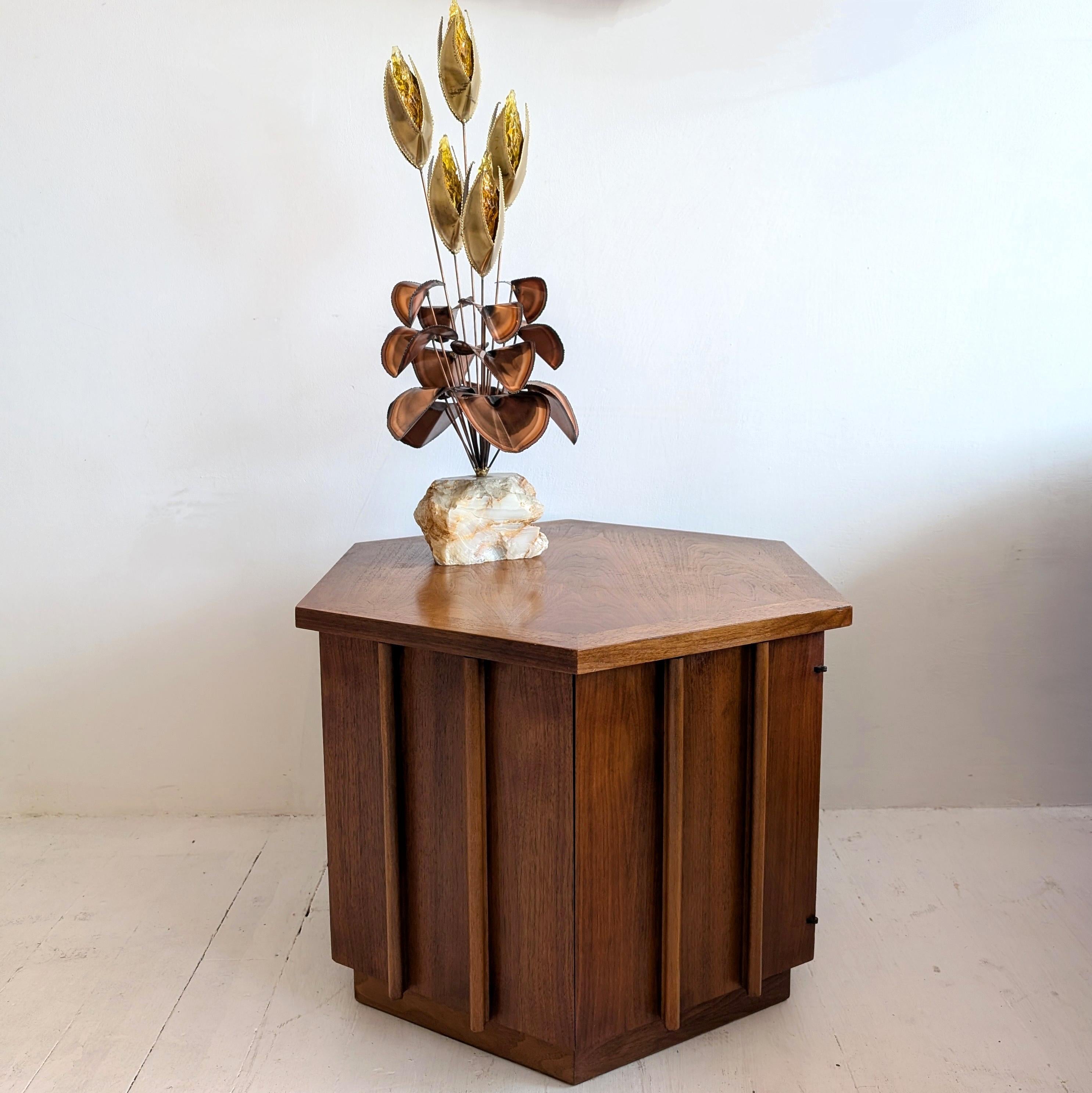 A superb brutalist hexagonal cabinet/end table by Lane Furniture, USA, 1970s. In walnut, with one door which opens to reveal storage. 
