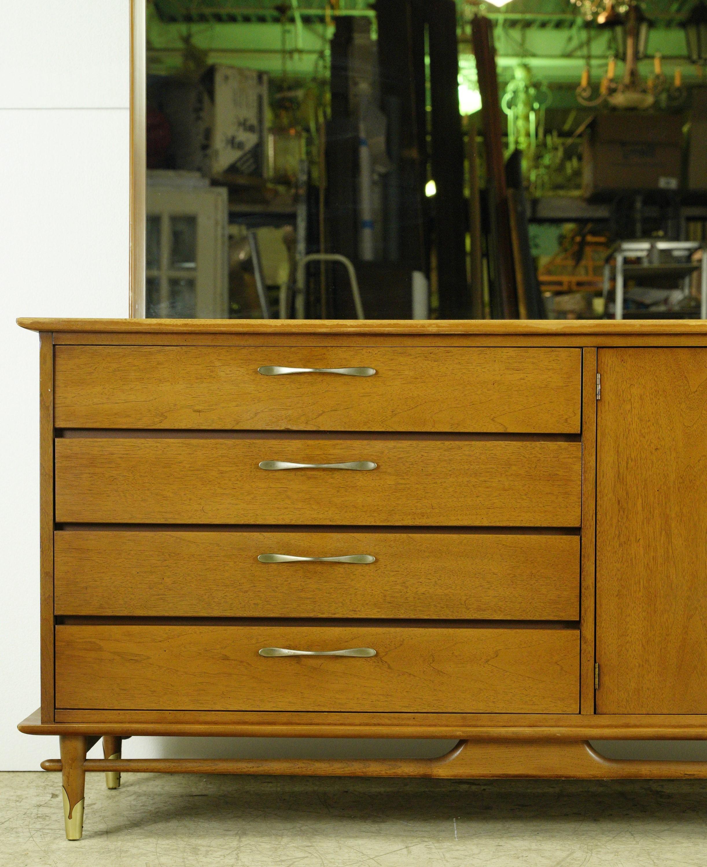 Medium tone Mid-Century Modern chestnut dresser with four drawers, two cabinet doors and a large rectangular mirror. Made by Lane. Good condition with appropriate wear from age. One available. Please note, this item is located in one of our NYC
