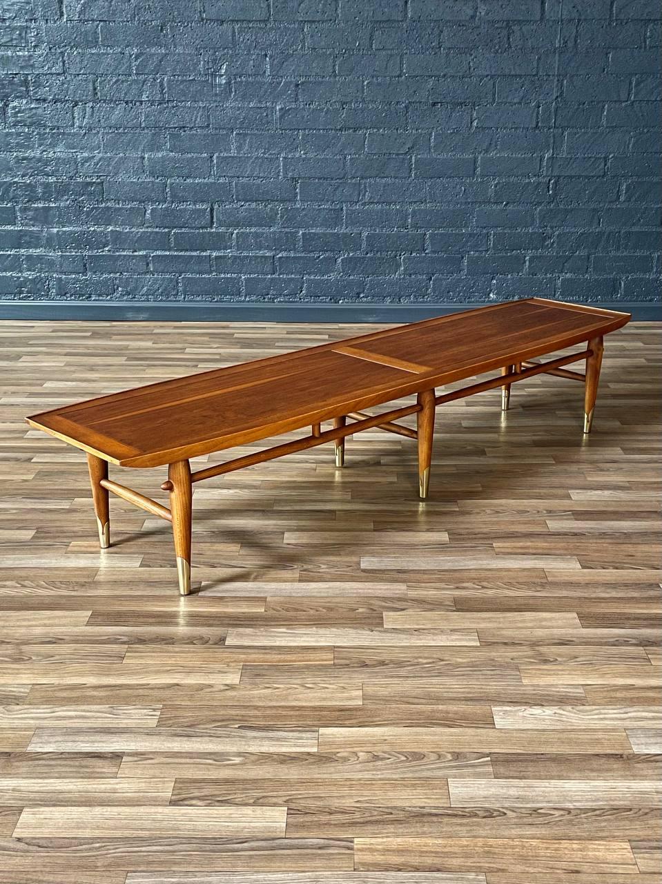 Condition: Original Vintage Condition 
Materials: Walnut, Brass Sabots 

Crafted by Lane in the 1950s, this “Copenhagen” coffee table/bench is a striking example of Mid-Century Modern design with refined Scandinavian influences. The walnut top