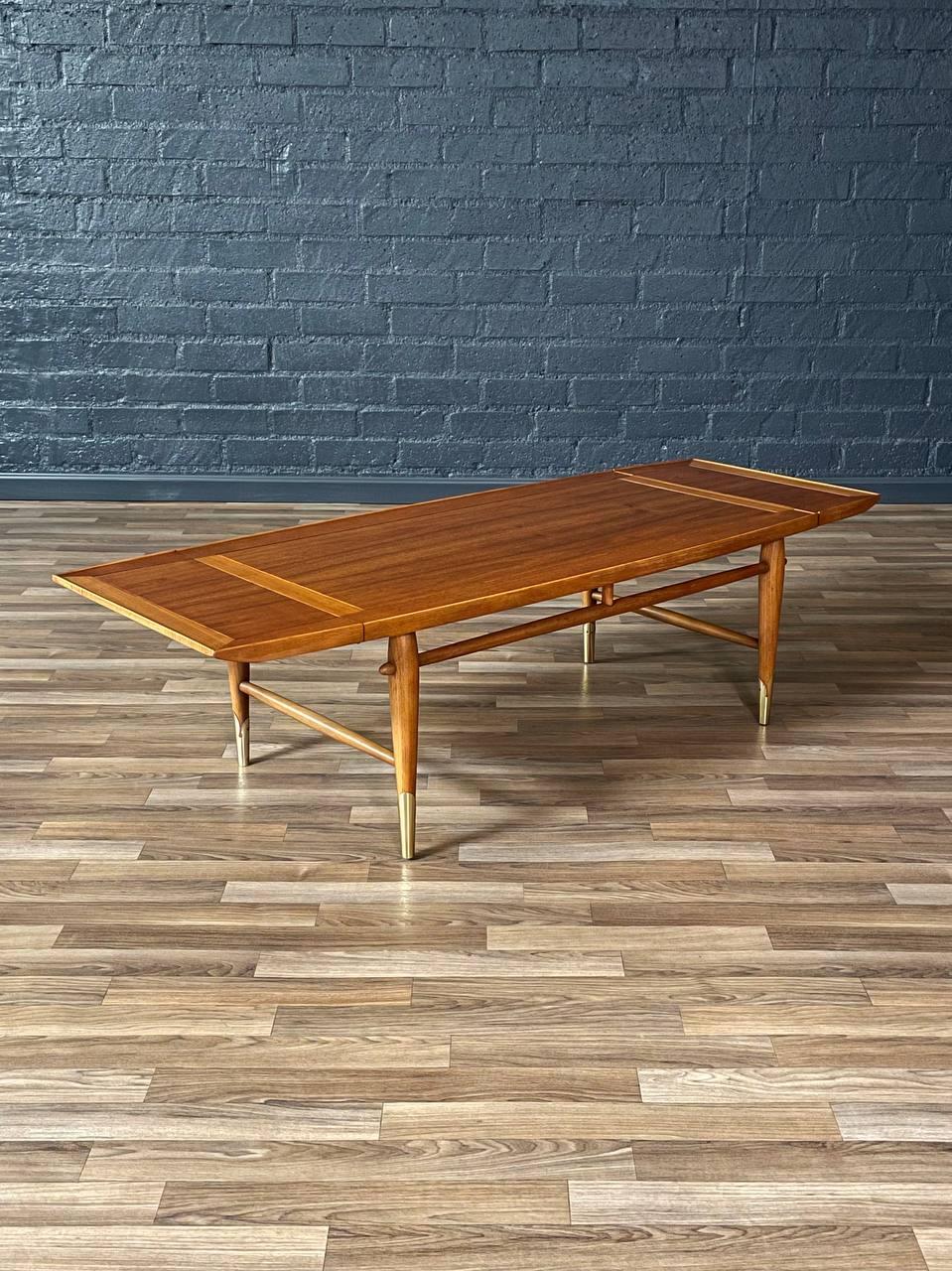 Condition: Original Vintage Condition 
Materials: Walnut, Brass Sabots 

Designed by Lane in the 1950s, this “Copenhagen” drop-leaf coffee table/bench is a versatile Mid-Century Modern gem. Crafted from richly grained walnut, the piece features dual