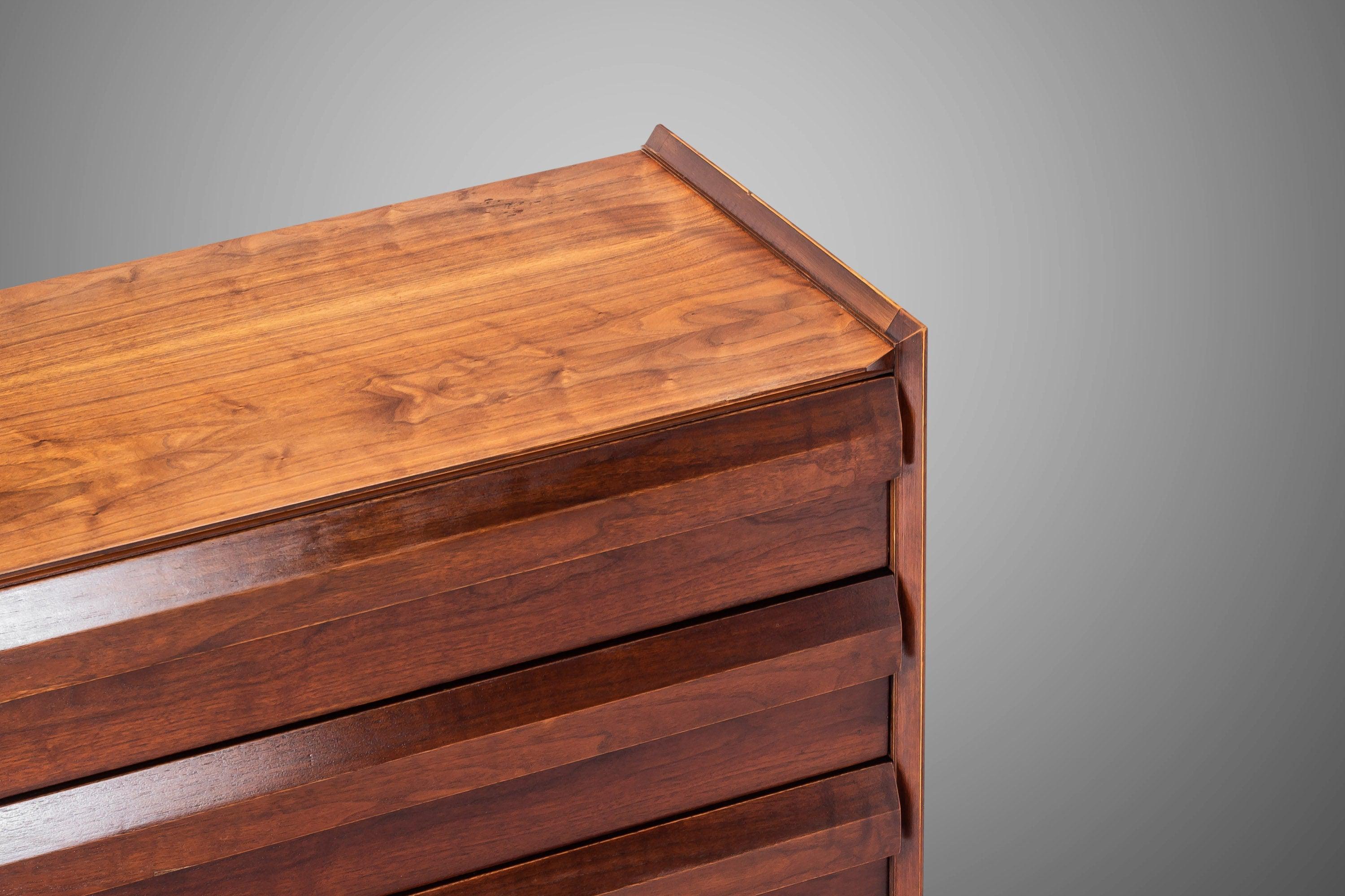 First Edition collection manufactured by Lane Furniture, Alta vista in the 1950s. The walnut and pecan composition features drawers with a sculpted, louvered drawer pulls and sharp, angular lines. The walnut exhibits outstanding grain patterns and