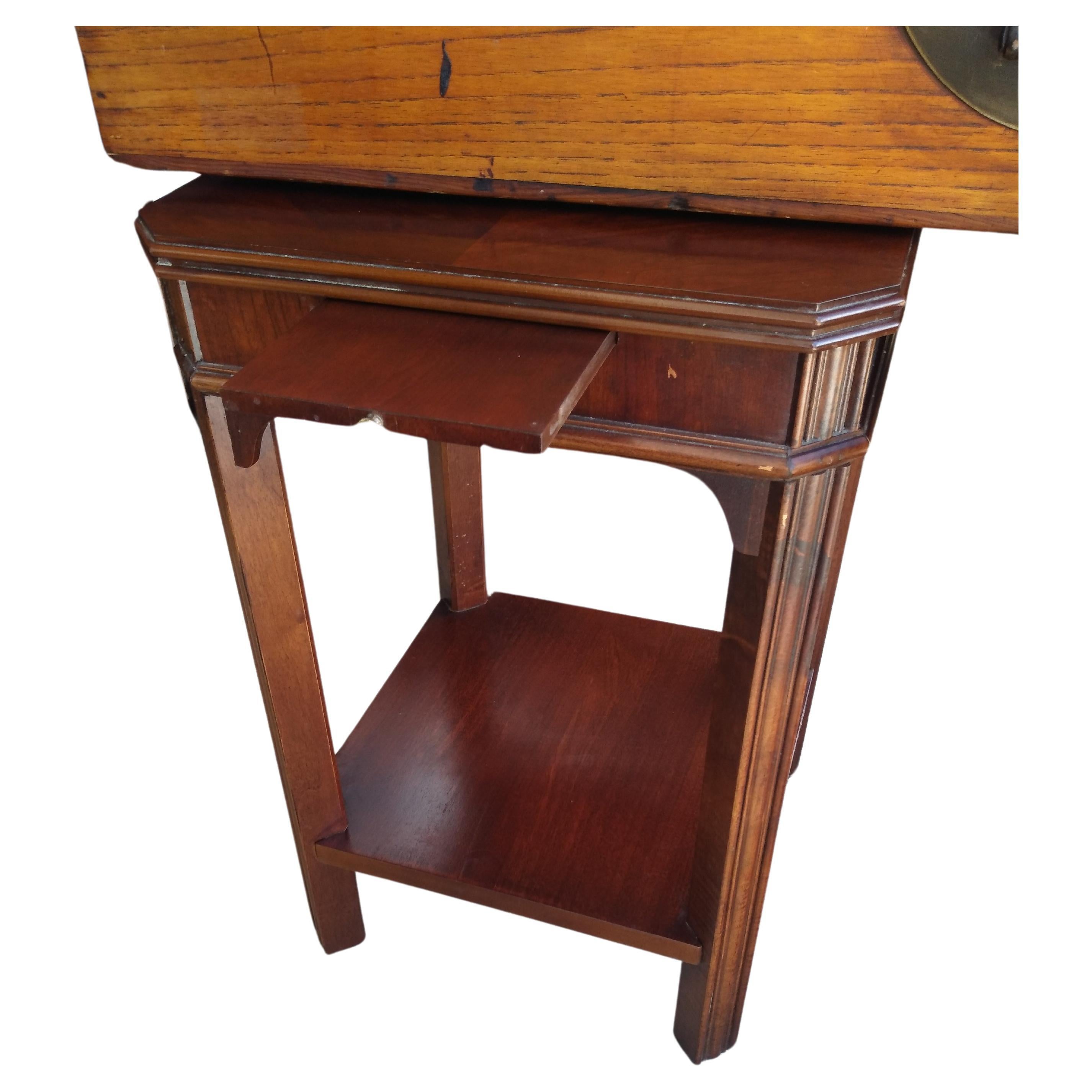 This low pedestal base is ideal for sculptures or decorative objects. It has a lower shelf for storage. It's crafted in the Chippendale style. 
