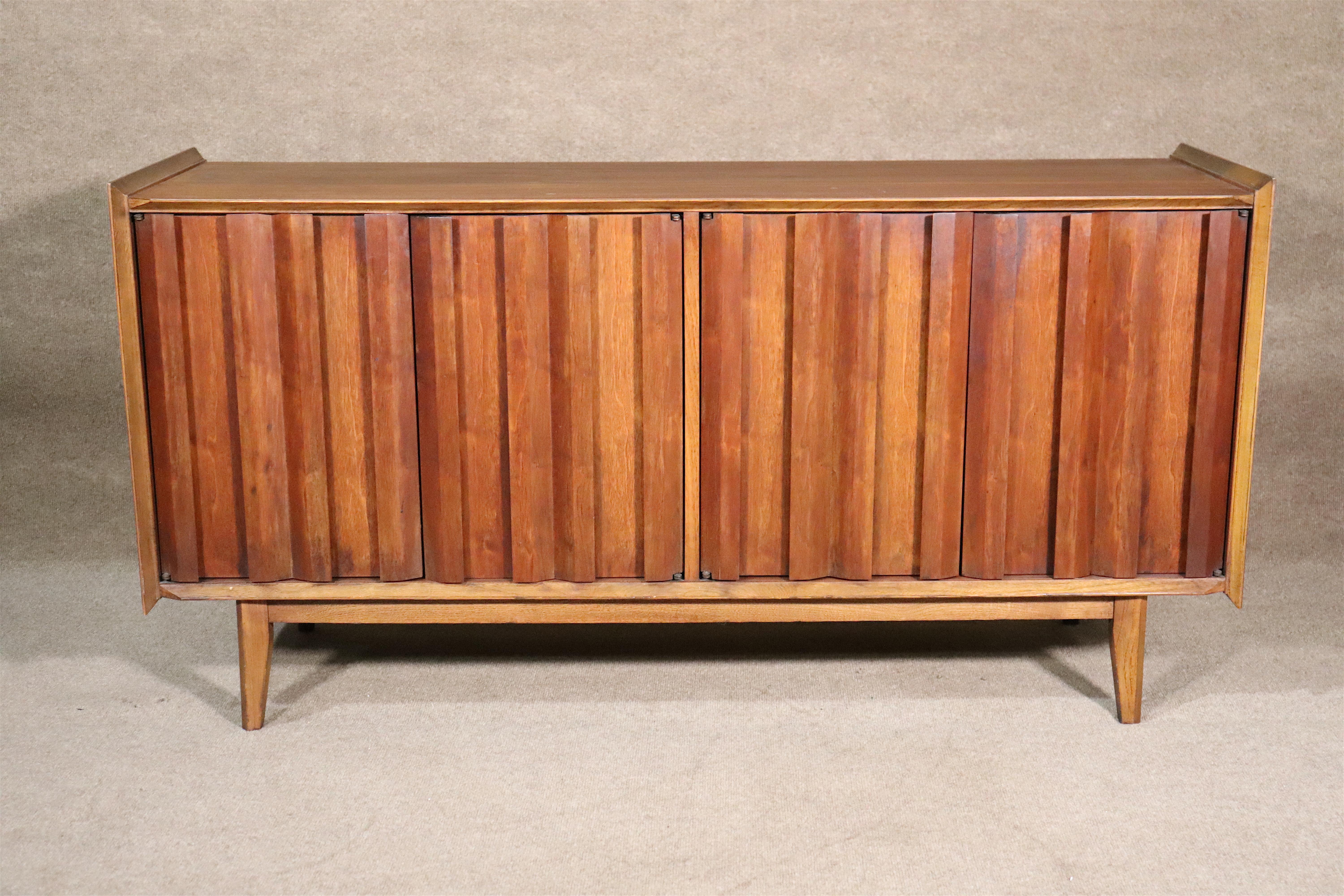 Mid-century modern cabinet with louvered front doors and cabinet storage. Made by Lane Furniture for their First Edition collection with sharp and sleek modern lines for bedroom or office use.
Please confirm location.