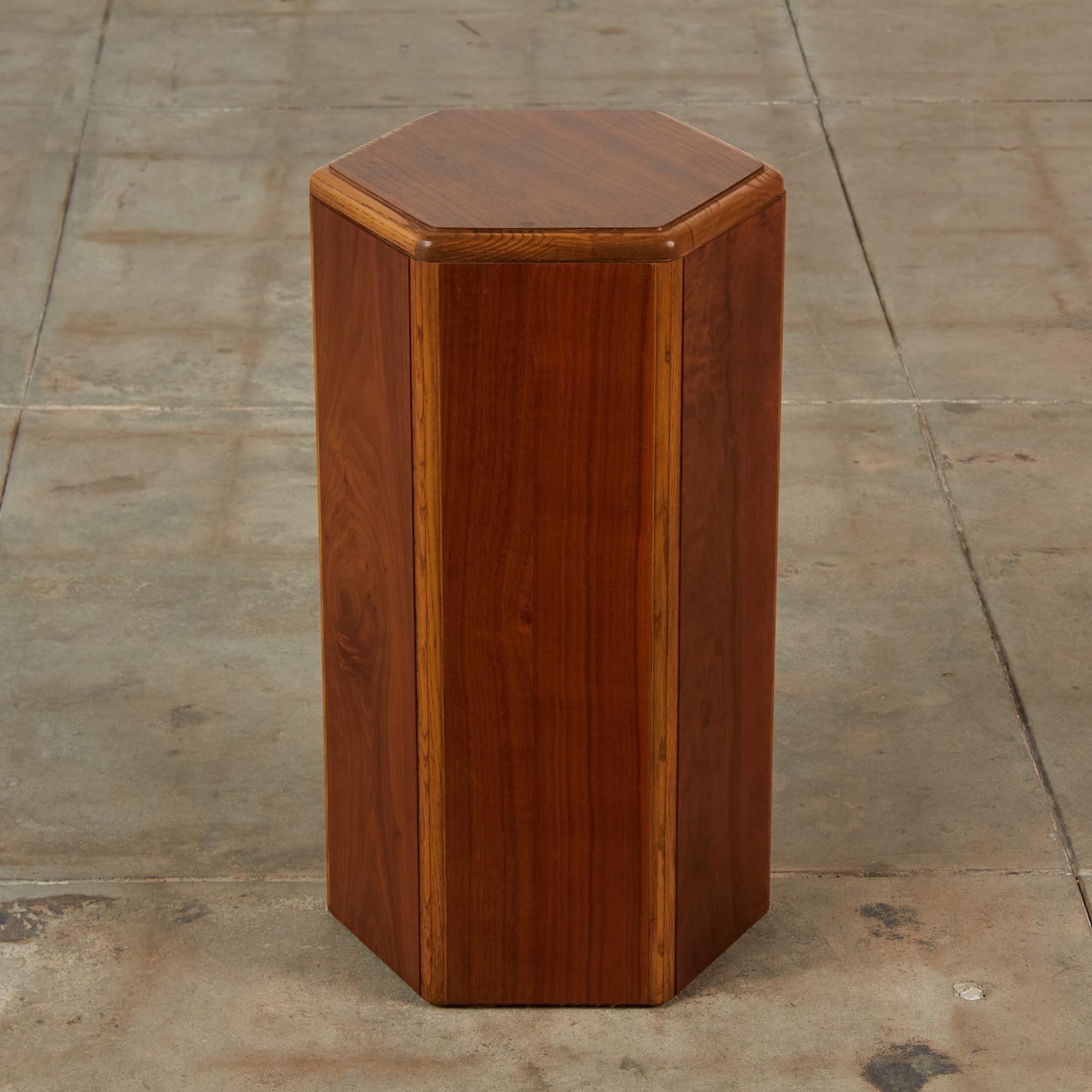 Lane hexagonal walnut and oak pedestal, c.1960s, USA. The pedestal features six walnut sides and top surface with an oak boarder. This petite pedestal would also serve as a unique side table.

Dimensions: 13.5” width x 12” depth x 24”