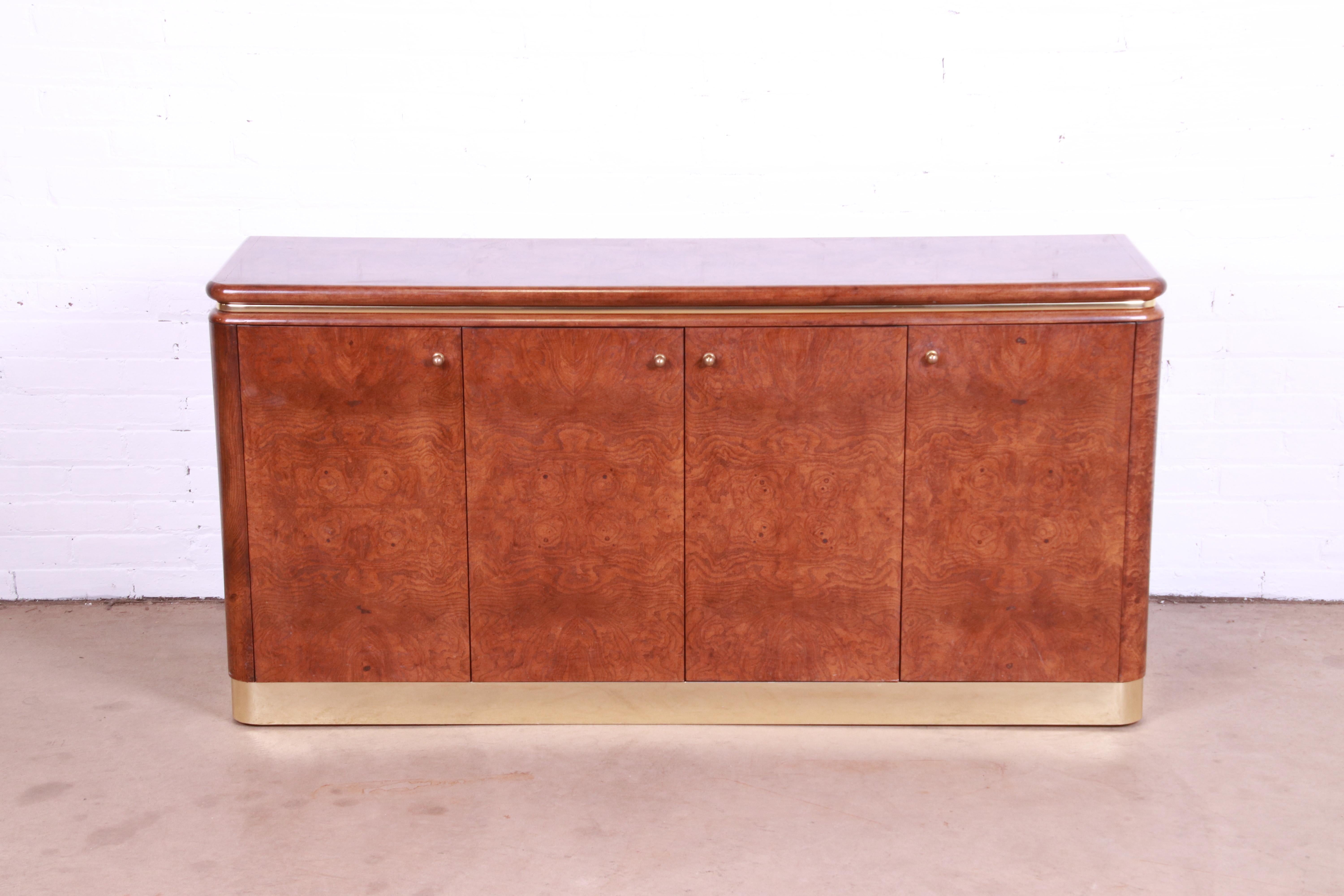 An exceptional Milo Baughman style Mid-Century Modern sideboard, credenza, or bar cabinet

By Lane Furniture

USA, 1970s

Gorgeous burl wood, with brass trim and plinth base, and original brass hardware.

Measures: 60