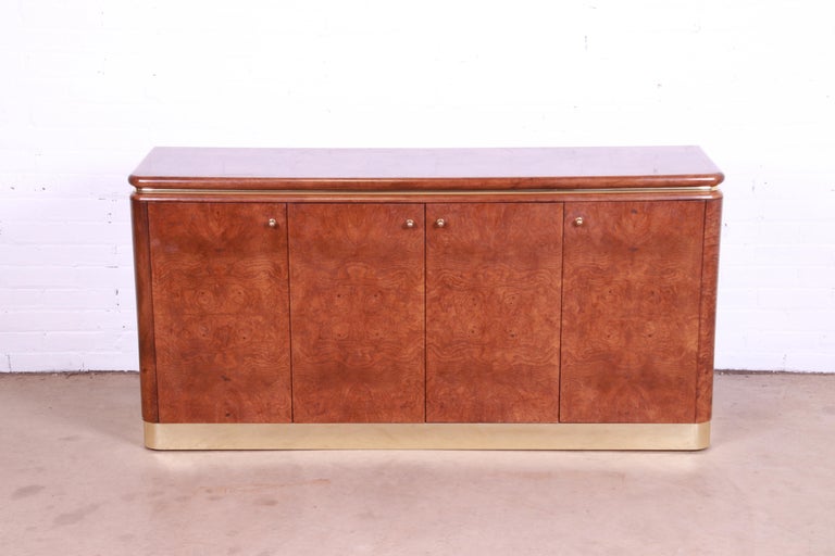 An exceptional Milo Baughman style Mid-Century Modern sideboard, credenza, or bar cabinet

By Lane Furniture

USA, 1970s

Gorgeous burl wood, with brass trim and plinth base, and original brass hardware.

Measures: 60