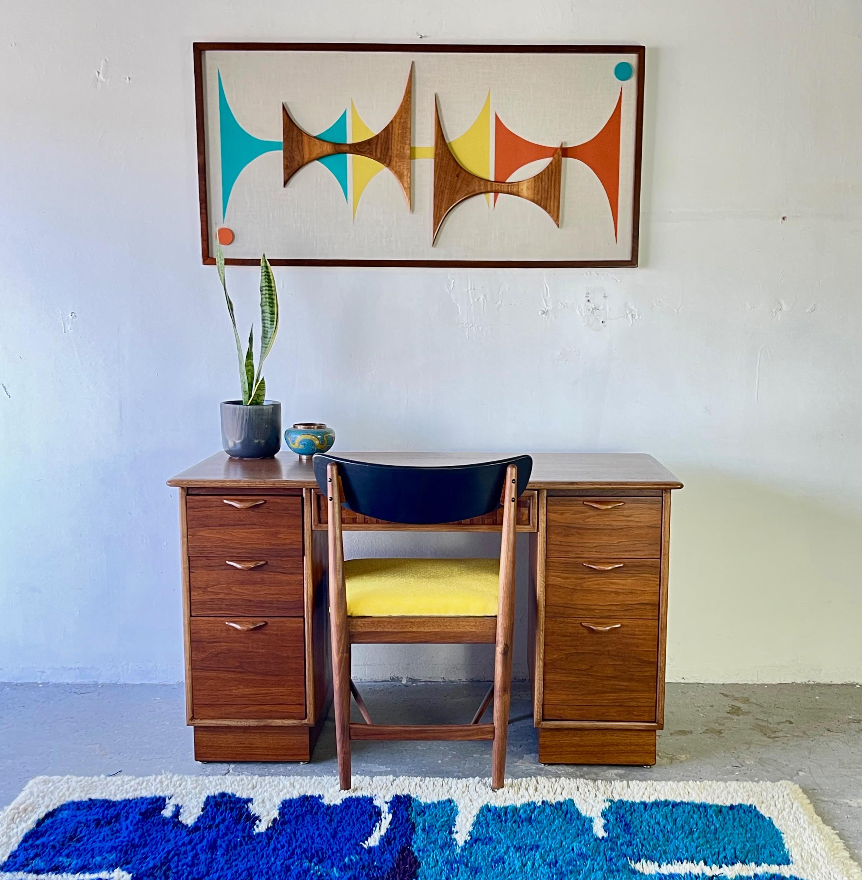 This Mid-Century Modern walnut desk from the Perception Collection by Lane Furniture features a finished back and the central drawer is the iconic three dimensional weave / woven, wood facade. all smooth sliding, dovetailed drawers. Desk is on a