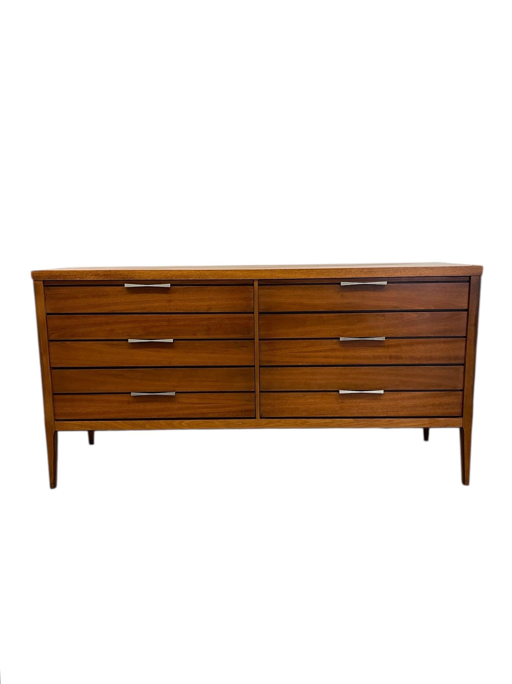 Authentic 1960s Lane dresser in rich walnut tones, featuring six smooth-gliding drawers with clean horizontal pulls. The minimalist silhouette is accented by a rare butterfly inlay detail across the top surface, showcasing high-quality craftsmanship