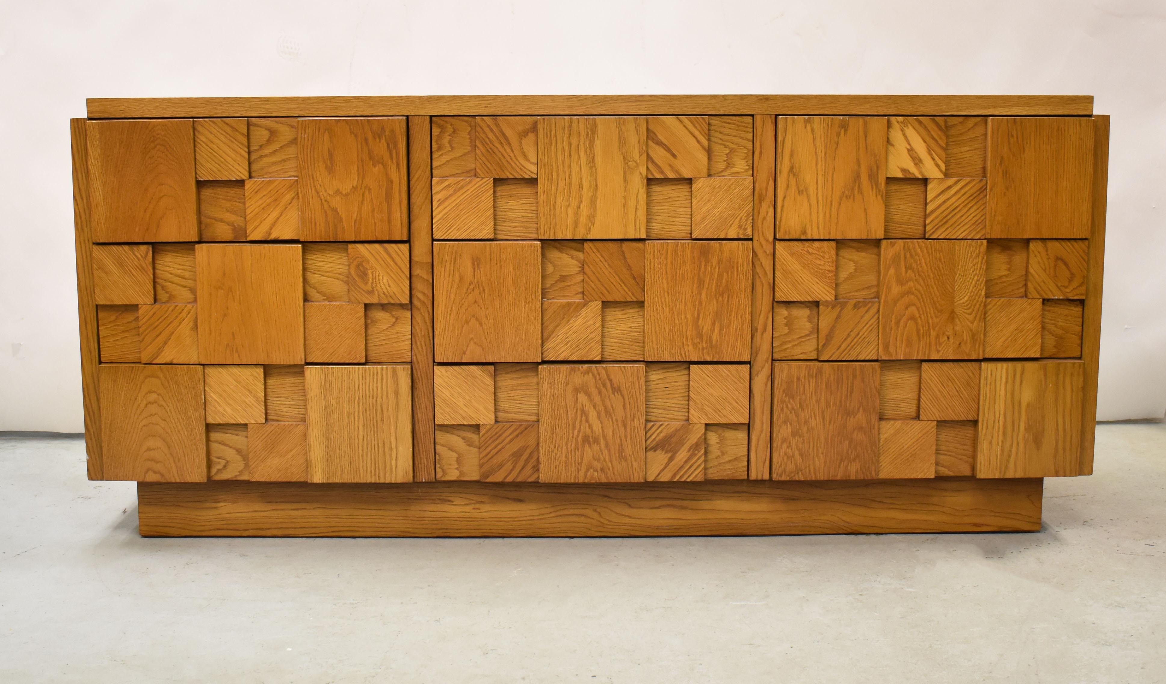 This unique low dresser is from the Mosaic Line by Lane Furniture. Inspired by the Brutalist style of Paul Evans, this piece is crafted from oak and has been meticulously cared for. Stamped on the inside drawer.