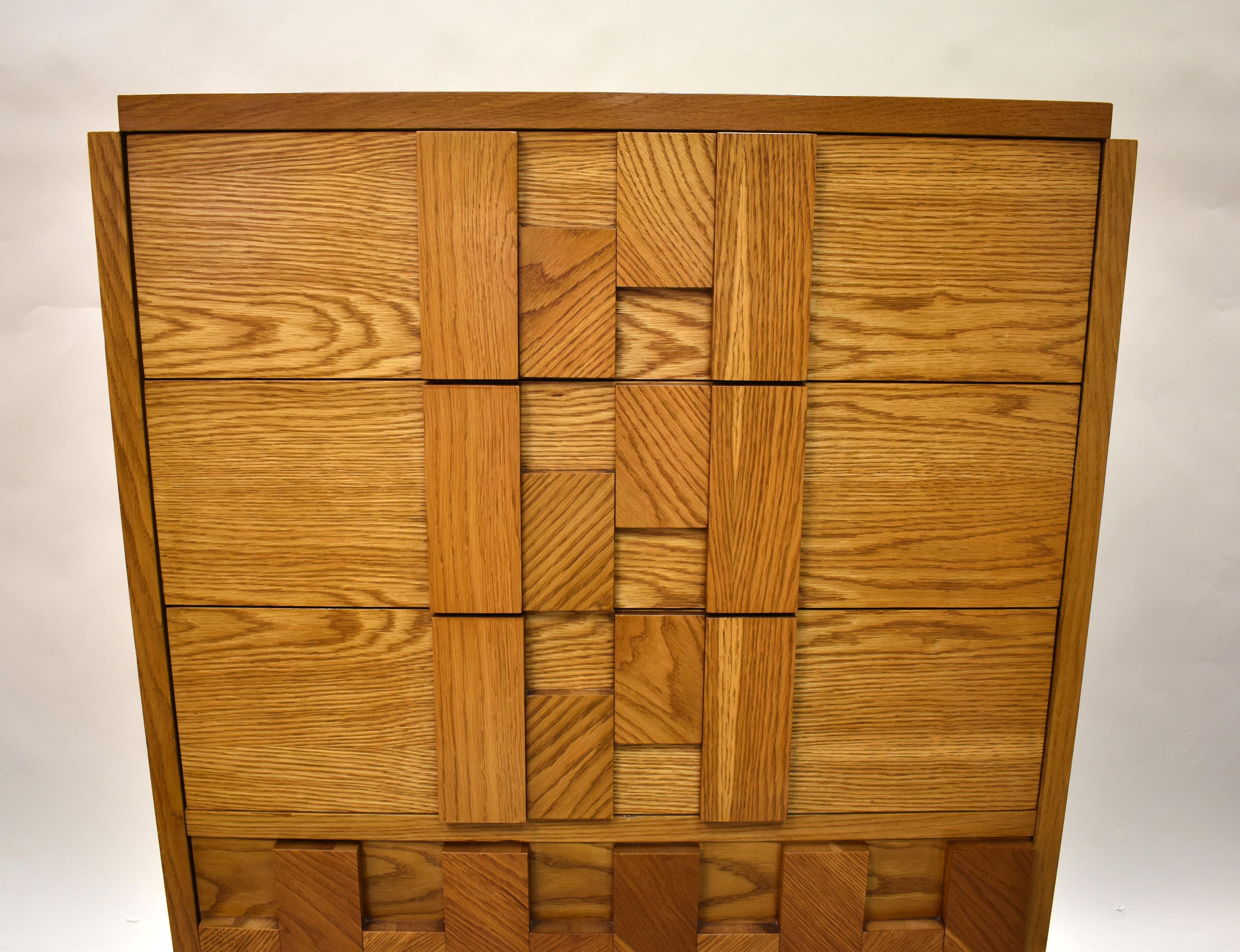 This tall chest is from the Mosaic line from Lane Furniture, inspired by the Brutalist style of Paul Evans. The dresser is crafted from oak and is in beautiful condition.