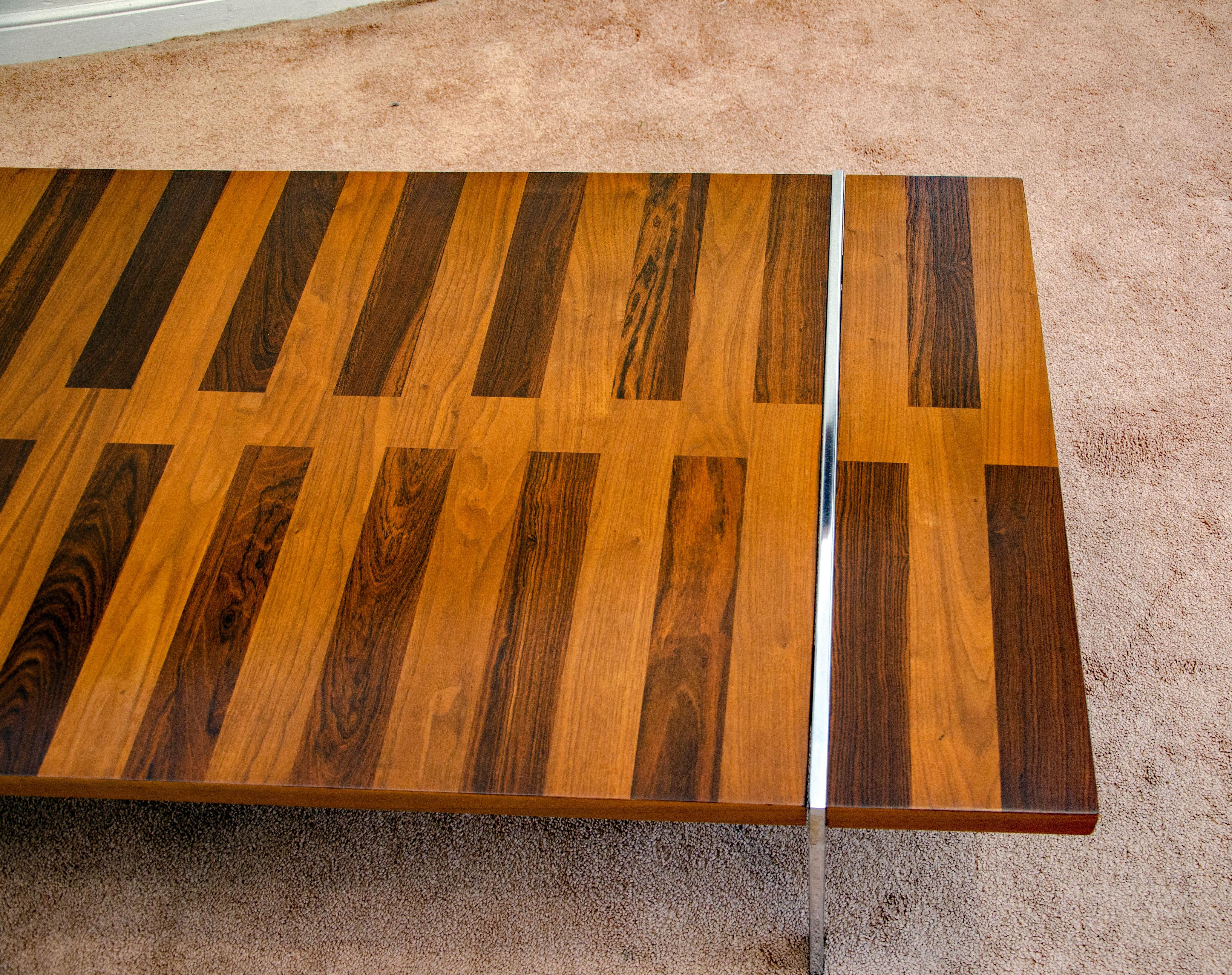 Interesting coffee table designed by Roland Carter and manufactured by Lane Altavista VA. The top has alternating strips of walnut and rosewood and is accented by a chrome-plated flat bar steel frame, which is very sturdy.