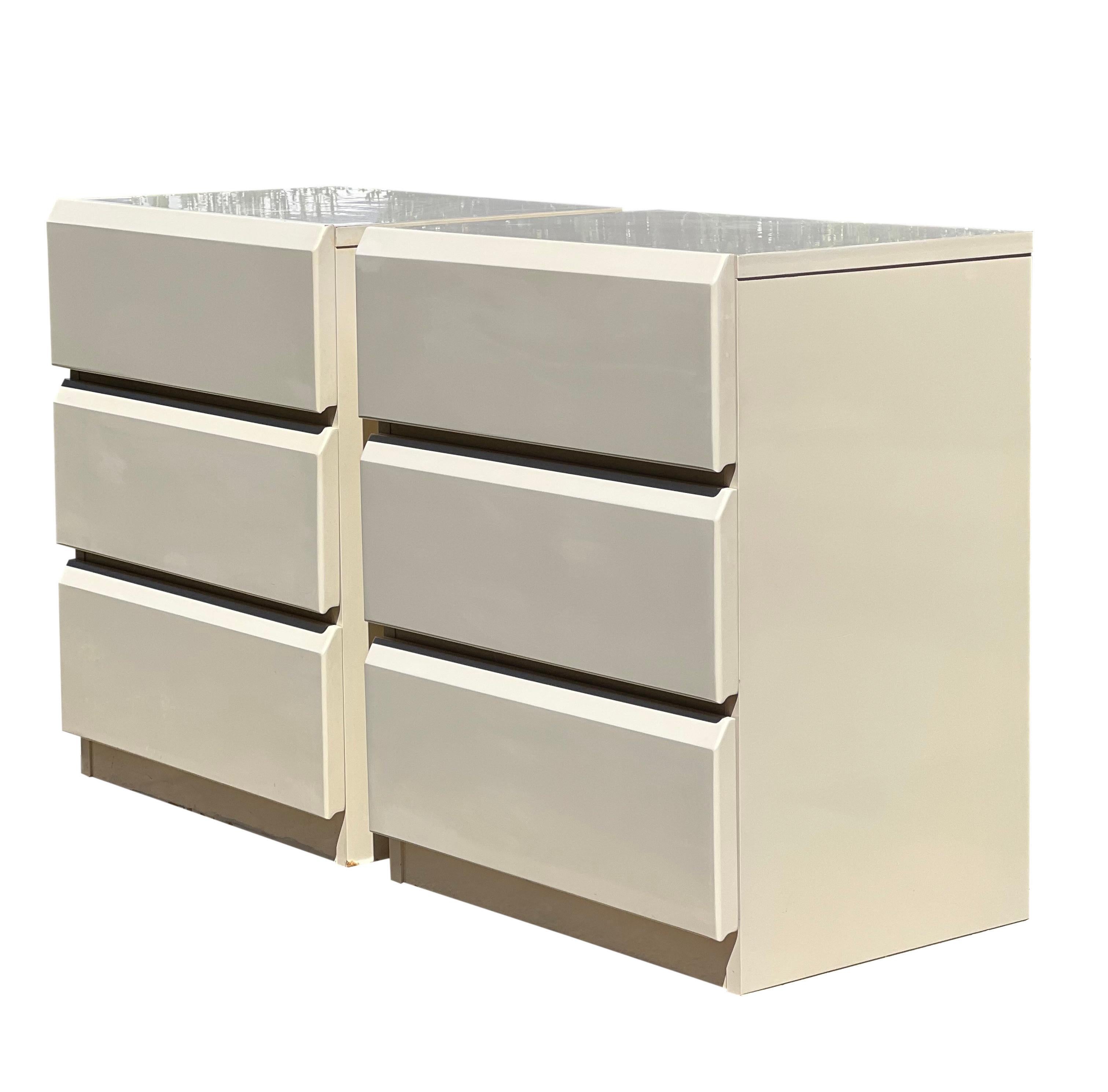 Fabulous pair of Post-Modern nightstands or chests by Lane, Altavista.

The stands feature a high gloss, protective lacquer in creamy white over solid wood. They offer lots of storage with three large, clean drawers which operate smoothly. The