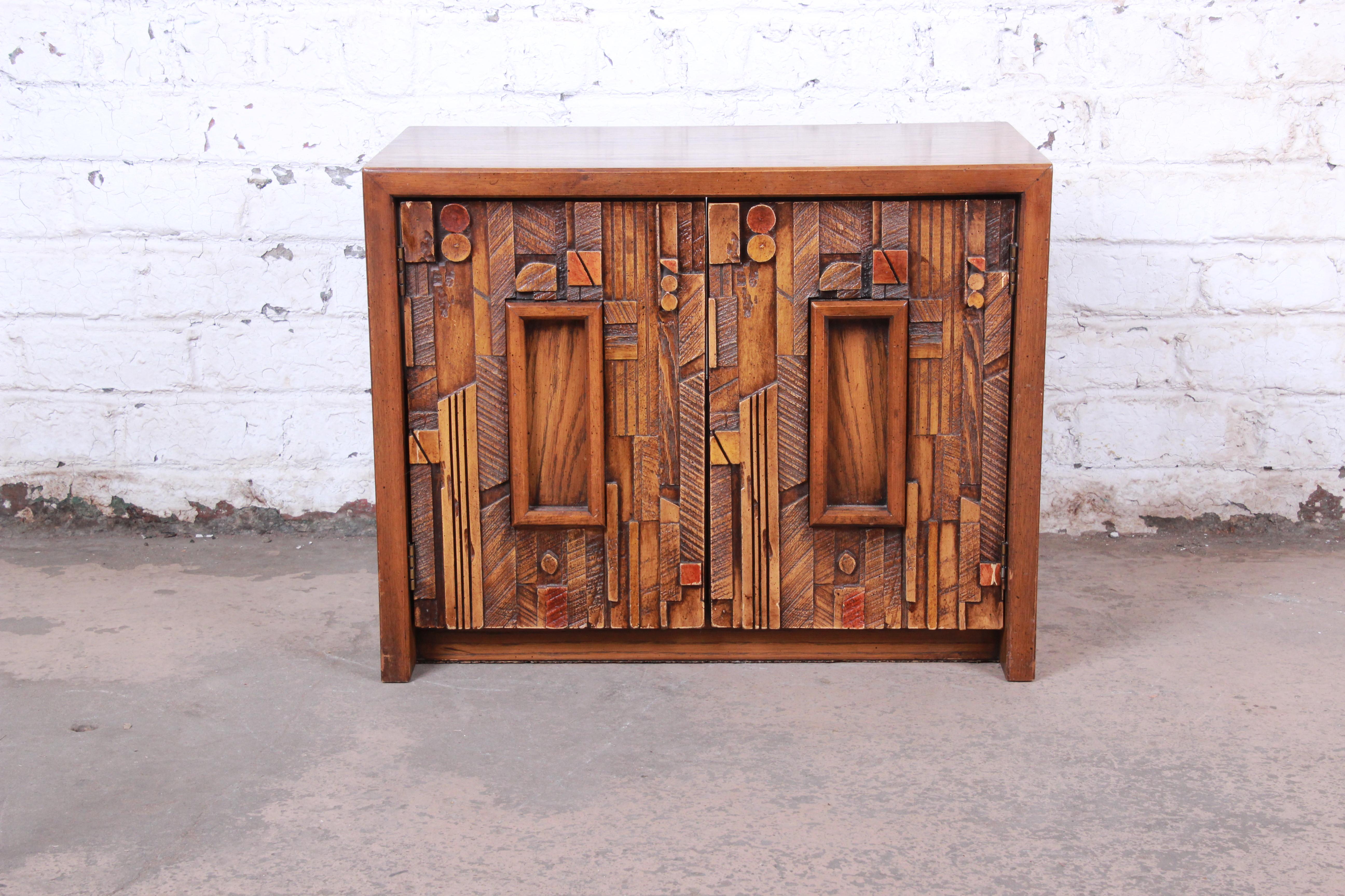 An exceptional Mid-Century Modern Brutalist nightstand or end table from the Pueblo collection by Lane. The nightstand features beautiful oakwood grain and a unique Brutalist design in the style of Paul Evans. It offers good storage, with a single