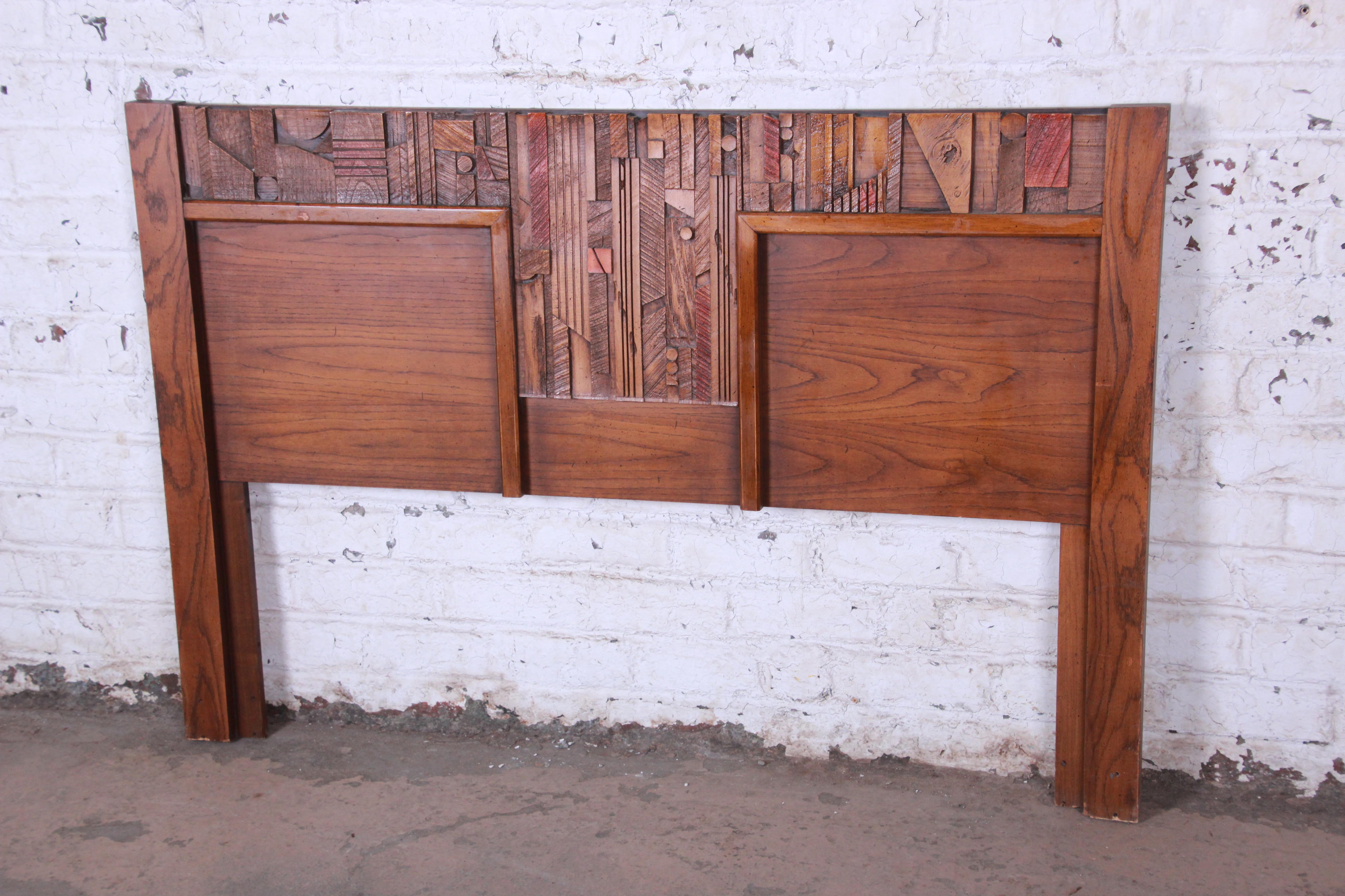 A gorgeous Mid-Century Modern Brutalist queen size headboard from the Pueblo collection by Lane. The headboard features beautiful oakwood grain and a unique Brutalist design in the style of Paul Evans. One of the more rare pieces from this highly