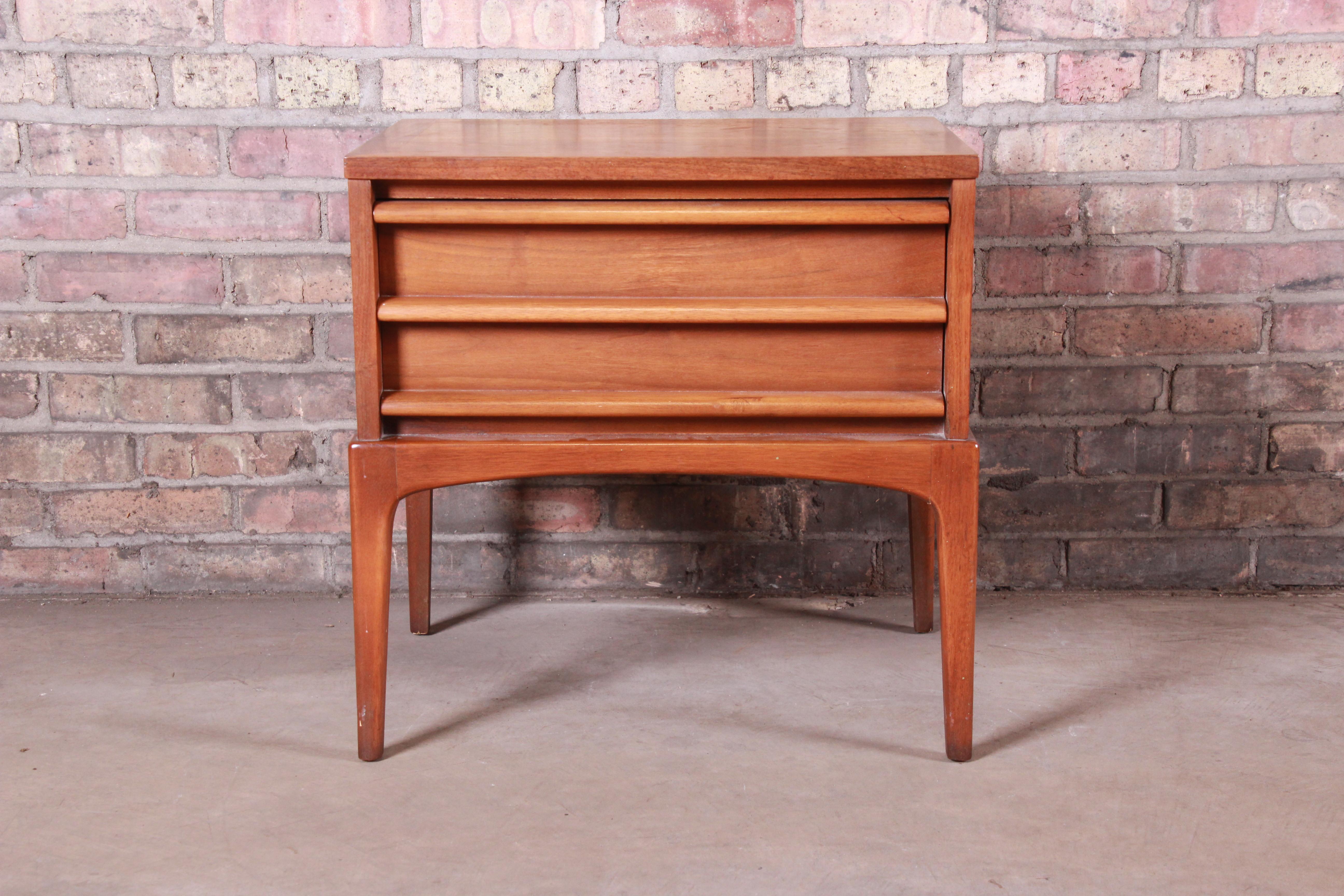 A sleek and stylish Minimalist Mid-Century Modern sculpted walnut nightstand or end table

By Lane Furniture 