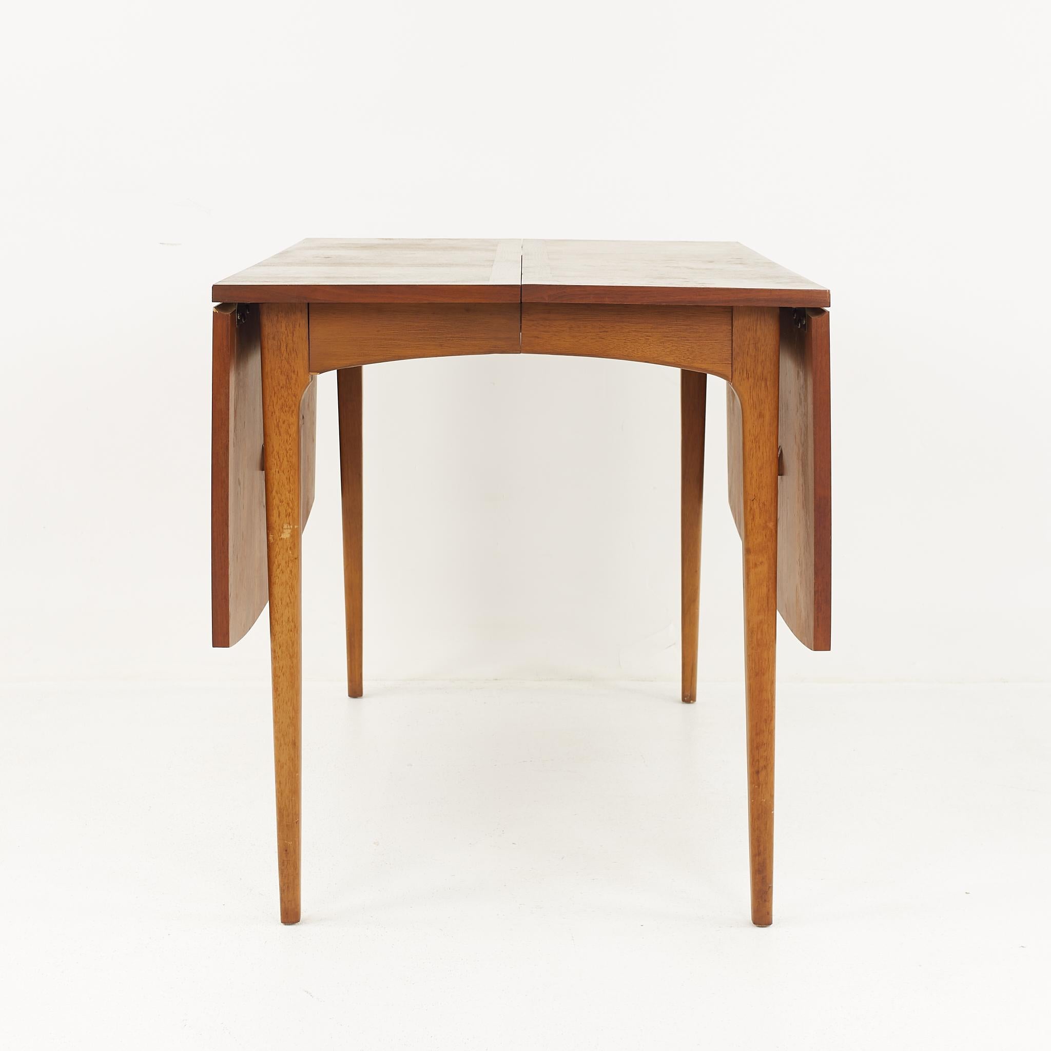 Lane Rhythm mid-century walnut drop leaf expanding dining table with 2 leaves

The table measures: 62 wide x 42 deep x 29.25 high, with a chair clearance of 25.75 inches; each leaf is 18 inches wide, making a maximum table width of 98 inches when