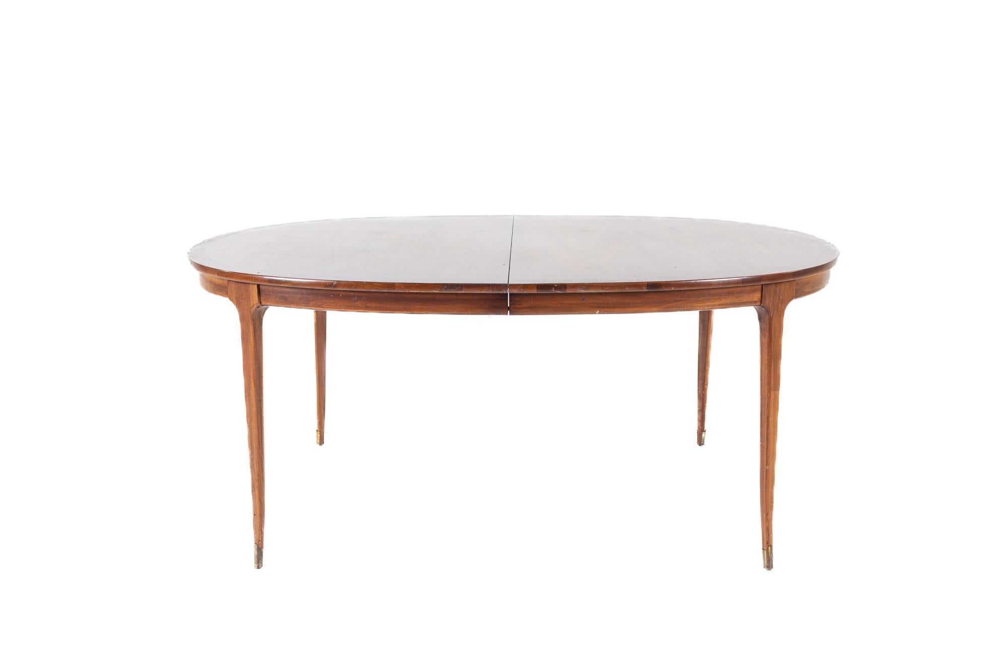 Lane Rhythm style mid century oval walnut dining table with brass tipped legs and 2 leaves

The table measures: 68 wide x 45 deep x 29.5 high, with a chair clearance of 26.5 inches; each leaf is 16 inches wide, making maximum table width of 100