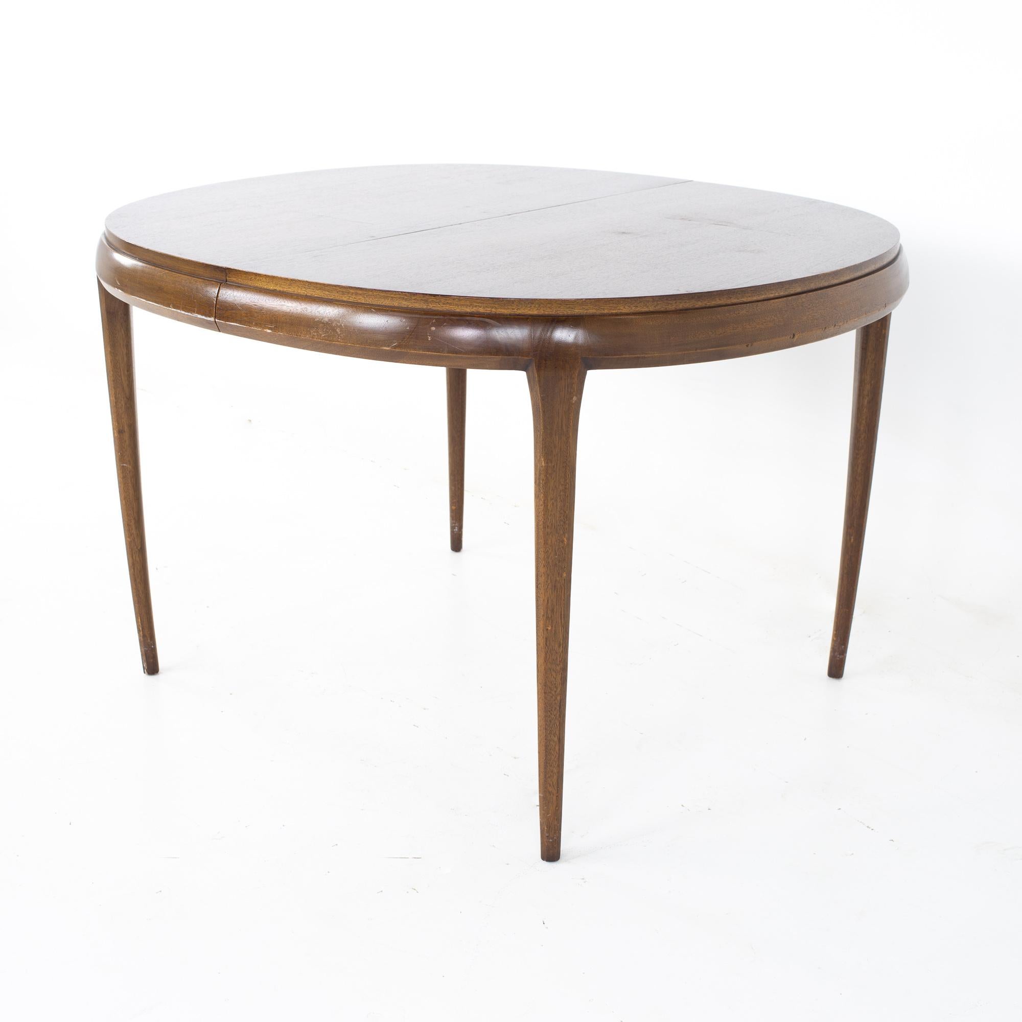 Lane Rhythm style Mid Century walnut round oval expanding dining table
Table measures: 46 wide x 42 deep x 29.5 inches high, each leaf is 18 inches wide, making a maximum table width of 100 inches when all three leaves are used.  This table has a