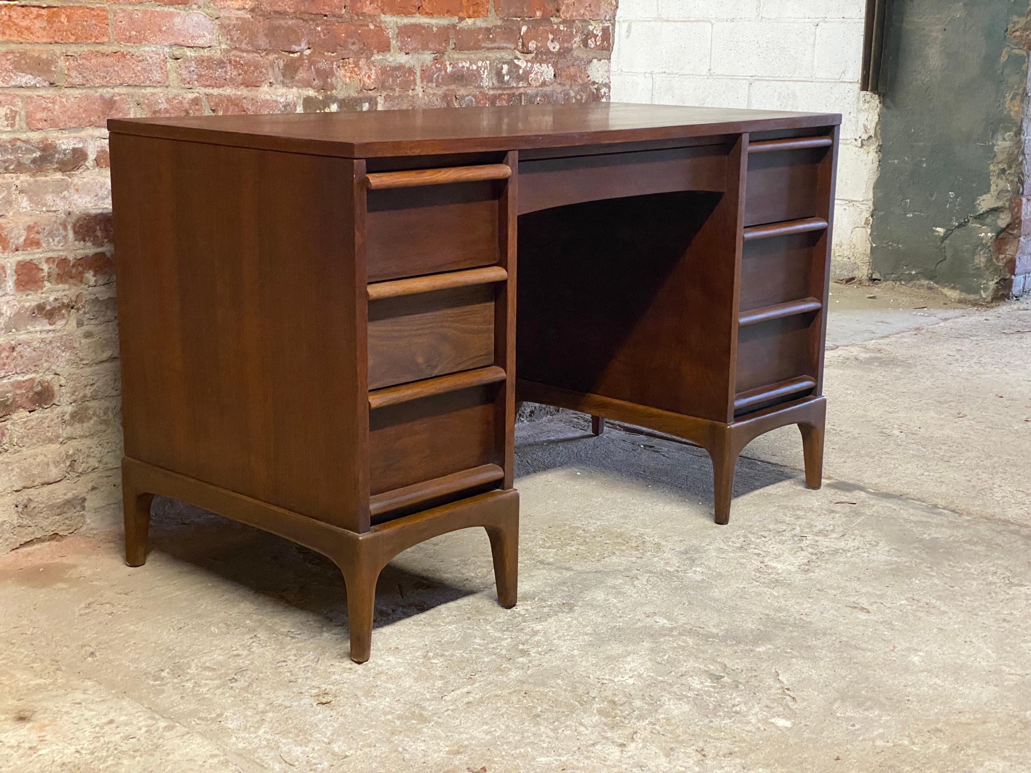 Lane Rhythm walnut desk. Featuring nicely figured and warm walnut veneers, six deep drawers, large work surface with contrasting banded inlaid edge. A long middle drawer (with channeled pen and pencil tray) is flanked by three and two drawers,