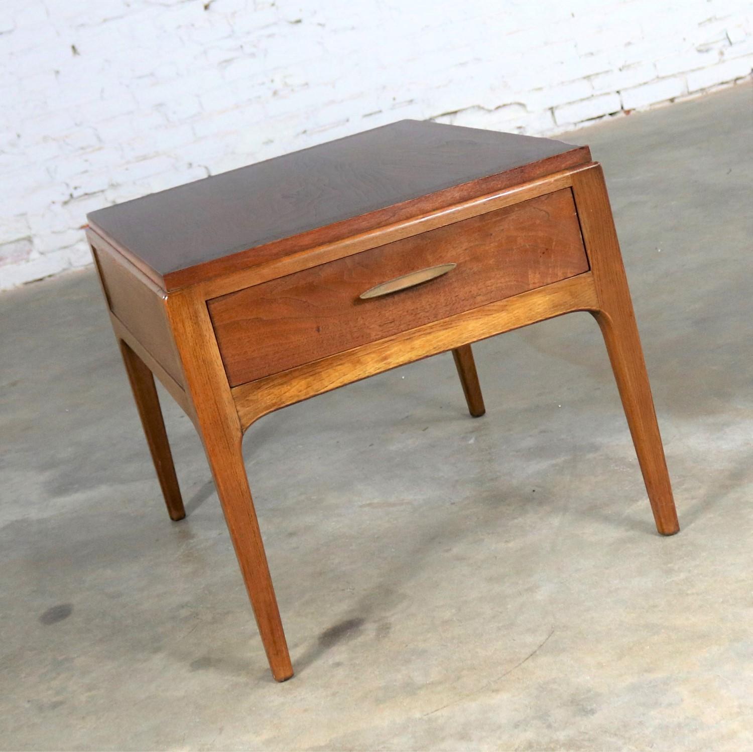 Iconic Mid-Century Modern walnut end table or side table by Lane Furniture for their Rhythm Collection. It is in wonderful vintage condition and ready to use. We have lightly sanded and restored the finish it to its beautiful original look, circa