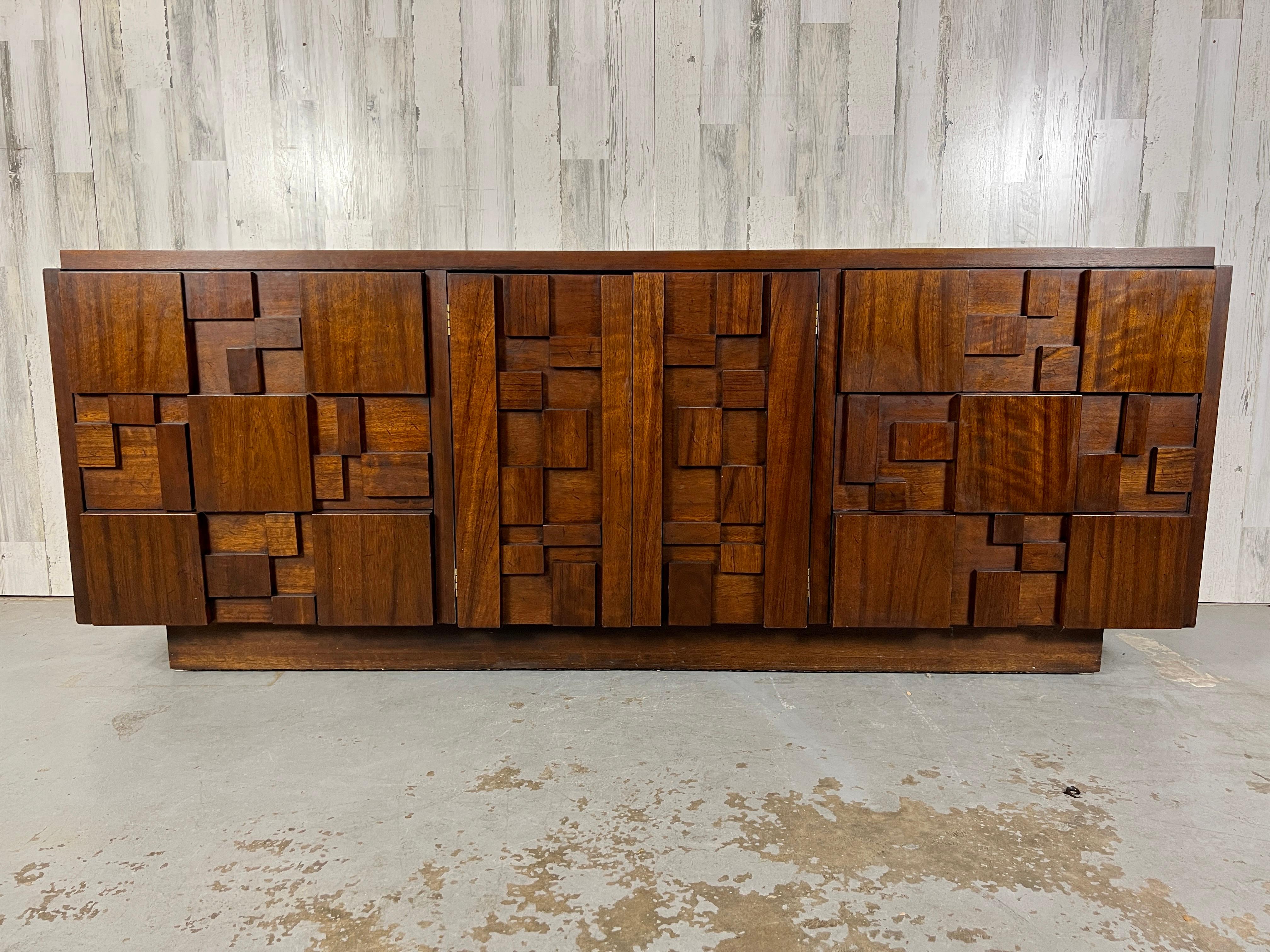 Brutalist design in the style of Paul Evans . Nine drawer dresser with three drawers on each side and three behind the center doors nice original finish.