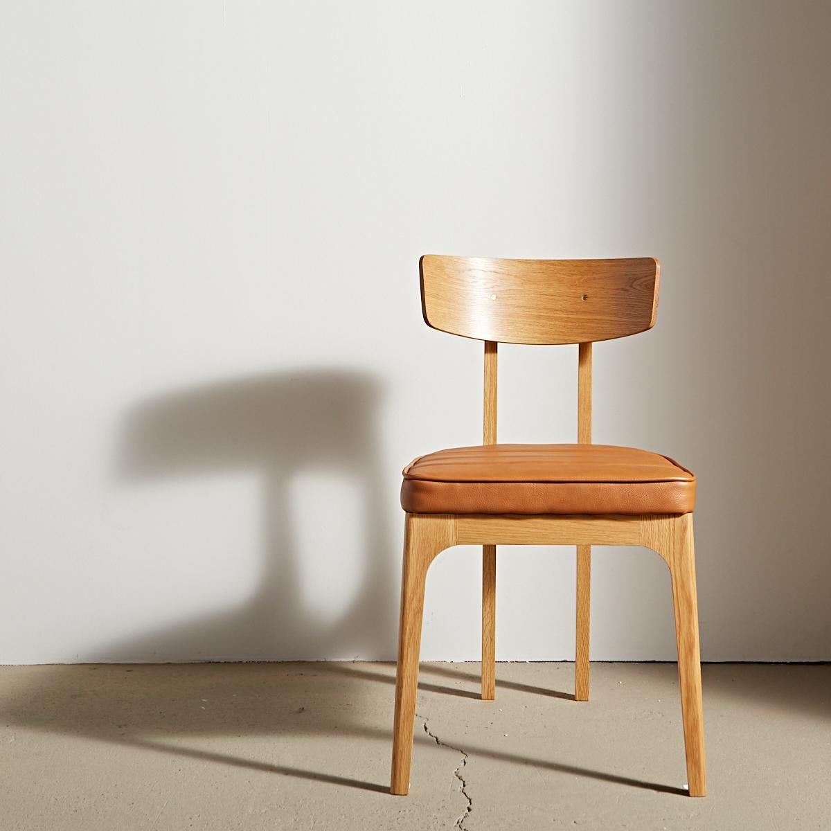 Unexpected angles provide an updated silhouette for a classic hardwood dining chair. Inspired by the European glamour of a Cafe Racer motorcycle, it has a strength and stability that defies the elegance of its slim legs. Featuring a bent solid