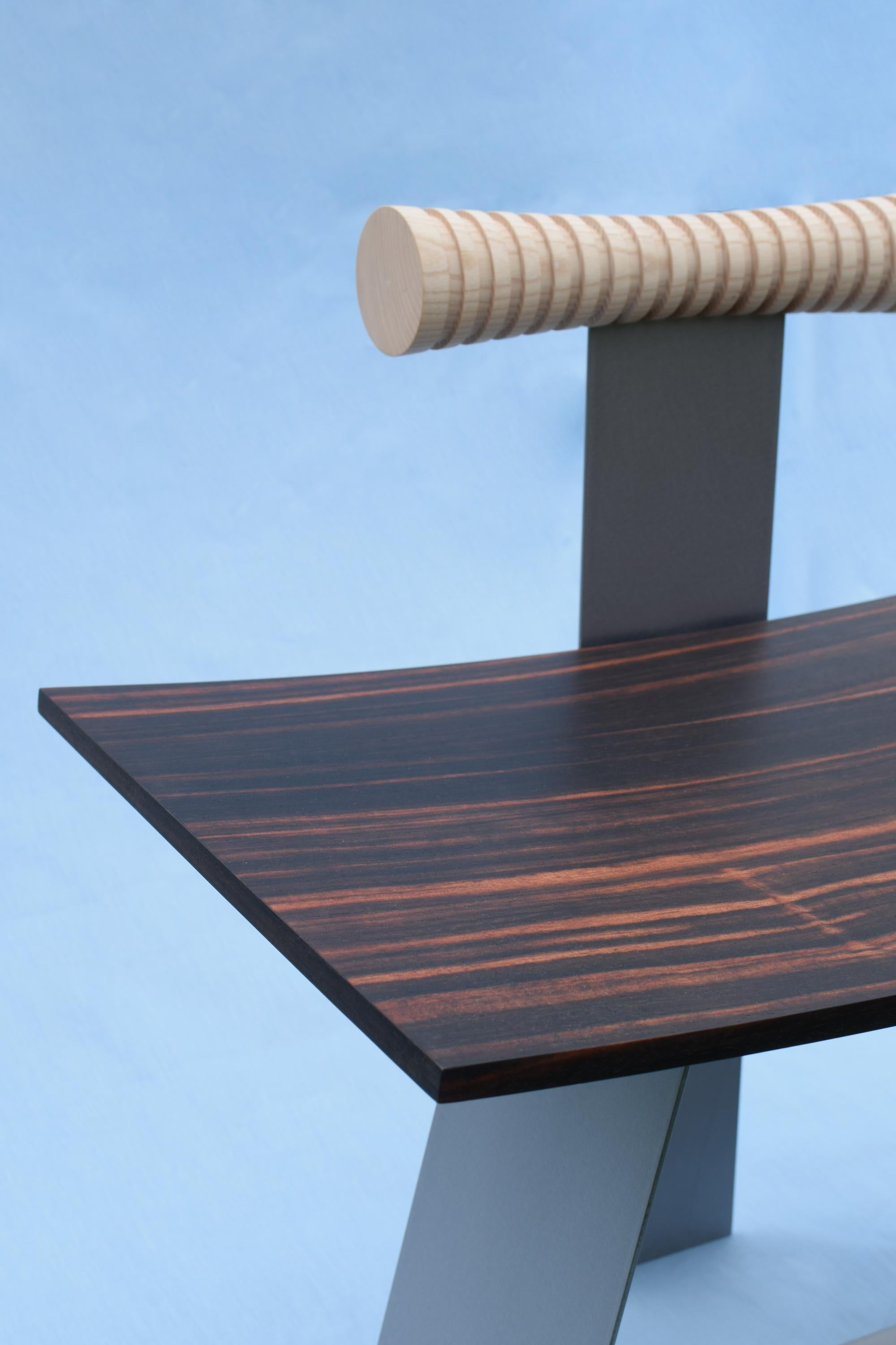 Dans un design plus audacieux, la froideur du métal contraste avec la chaleur accueillante du bois, tout en reflétant la motivation traditionaliste profondément ancrée de la marque. L'objet sculptural sert de pièce fonctionnelle : une combinaison de