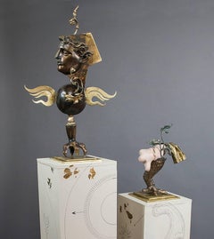 "The Lovers", gold and bronze colored figures, stand on paired pedestals 