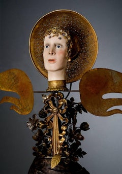 "Winged Virgin", female figure of wood, steel wings and golden halo