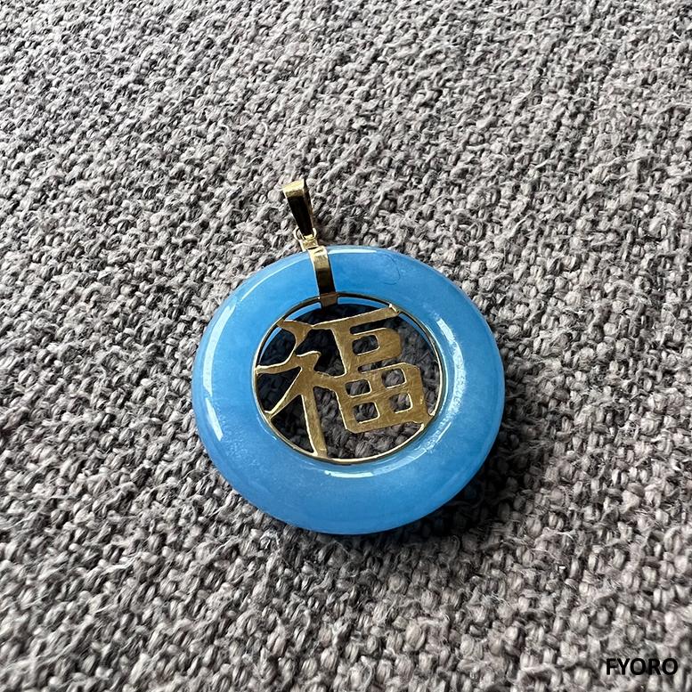 Blue Azure Jade Donut Pendant with the Chinese Han Character for 'Fortune' or 'Luck' in 14K Solid Yellow gold. 

The 'Lantau Azure Jade Fu Fuku Fortune Pendant' is a new iteration of our famed Jade Pendant. The Azure Jade represents a cool and