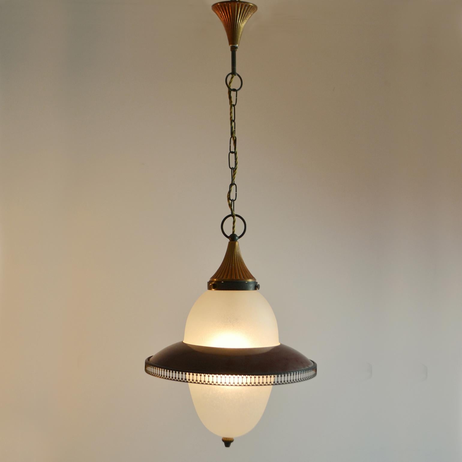 Frosted glass lantern with dark red metal shade like a Saturn ring and fine laced metal border is hanging from a chain and anodized copper ceiling rose, Italy 1950's. This pendant in warm tones of soft white, copper, Bordeaux red and brass is