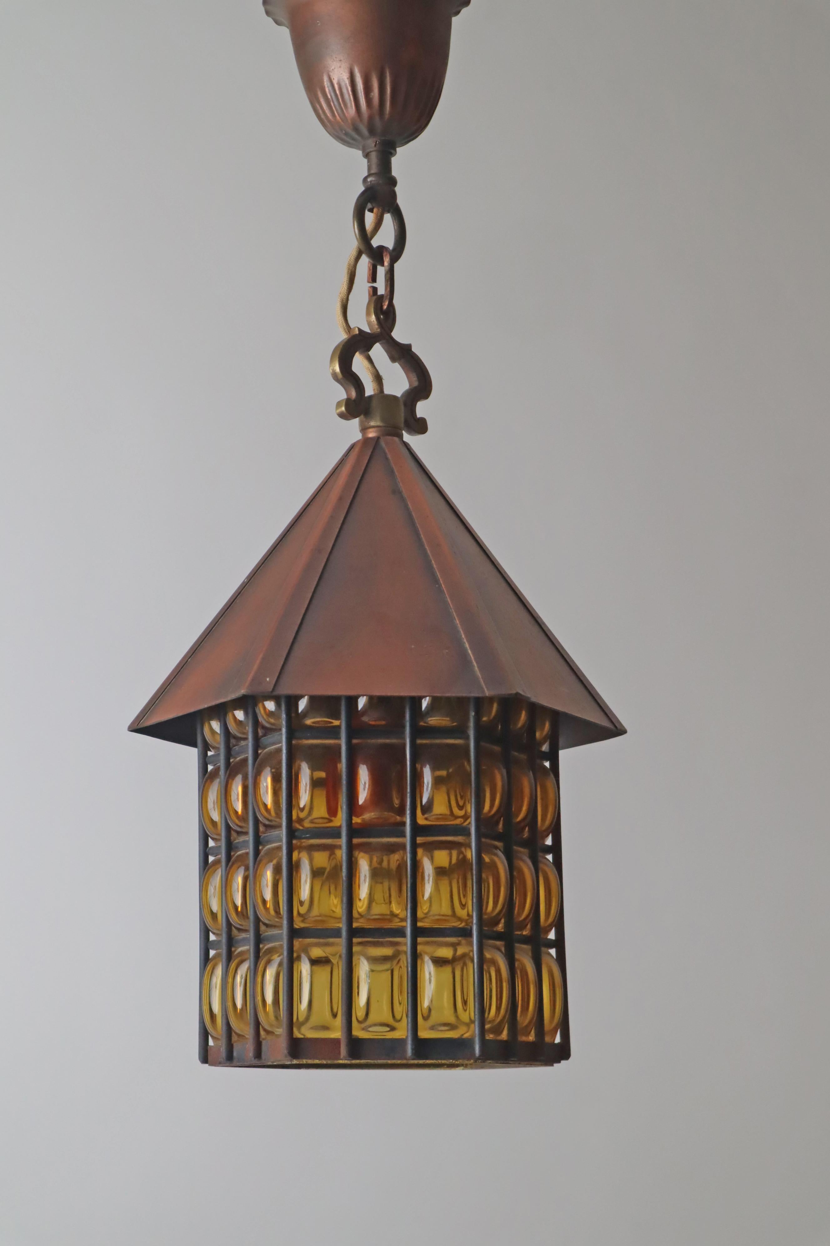 Ce magnifique Latern est fait de verre soufflé à la bouche et de cuivre. Cette lampe donne une impression de laiton et fournit un éclairage artmosphérique très spécial et unique dans la pièce ou à l'endroit où elle est suspendue. Sa forme lui permet