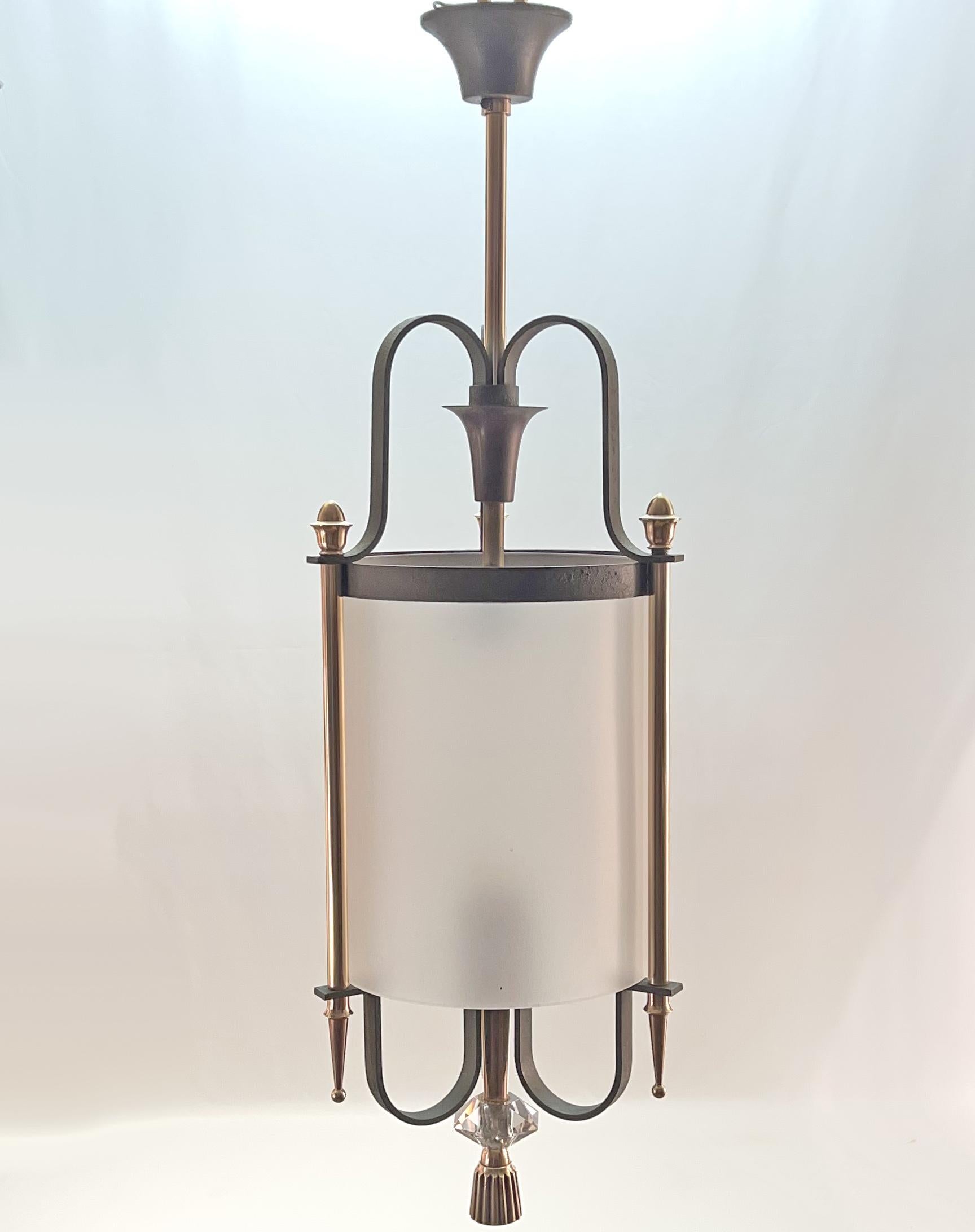 Elegant lantern circa 1940 in thick frosted cylindrical glass in a bronze and wrought iron frame with a nuanced green patina.
Attributed to Gilbert Poillerat
Perfect condition of presentation and operation (recent electrification)
Just need new