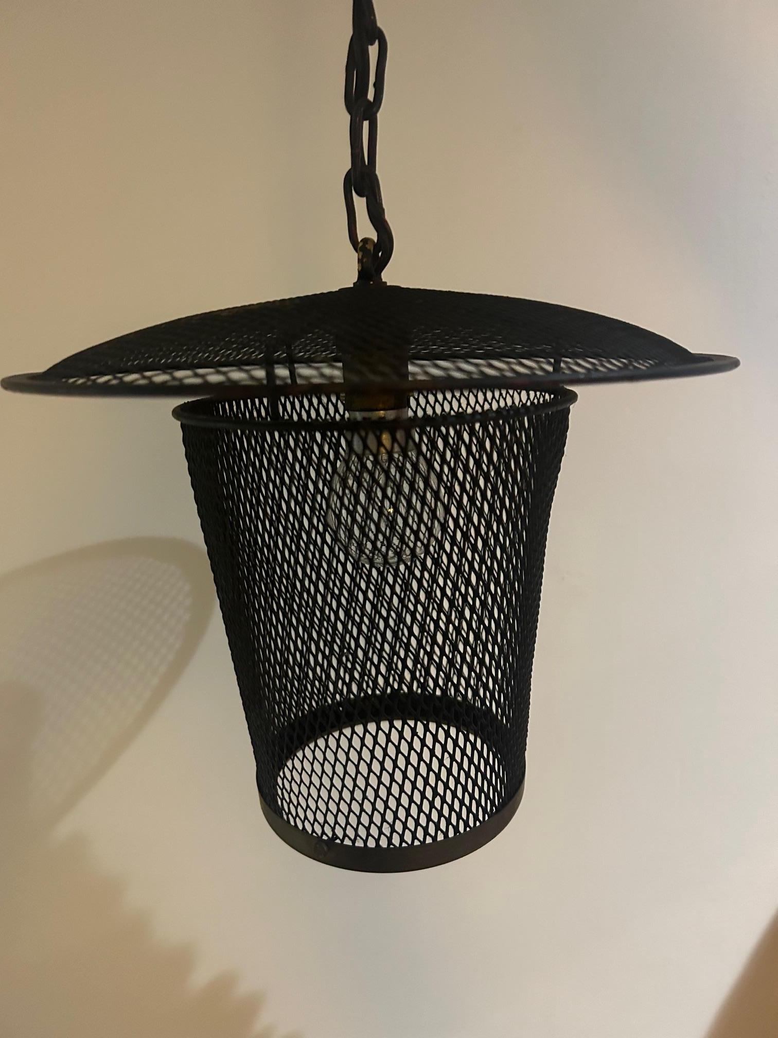 lámpara colgante de metal perforado que recuerda la obra de Mathieu Mategot , círculo de latón en la parte inferior 
Cadena de 25 m que sujeta la linterna 