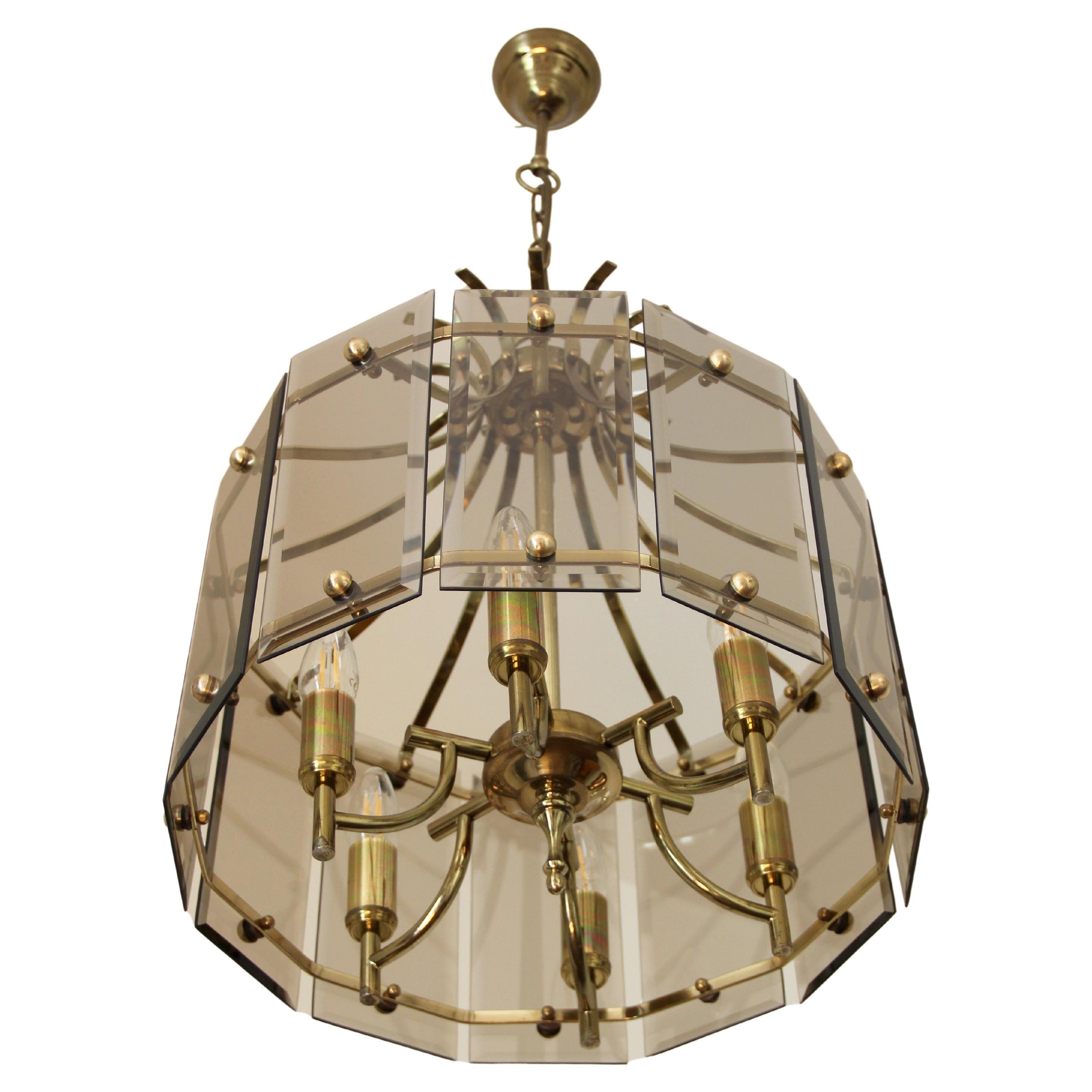 Pretty lantern from the 1970s in the style of Gibert Poillerat, in bevelled smoked glass plates and gilded brass. Six lights. 

Height is given without chain and pavilion.