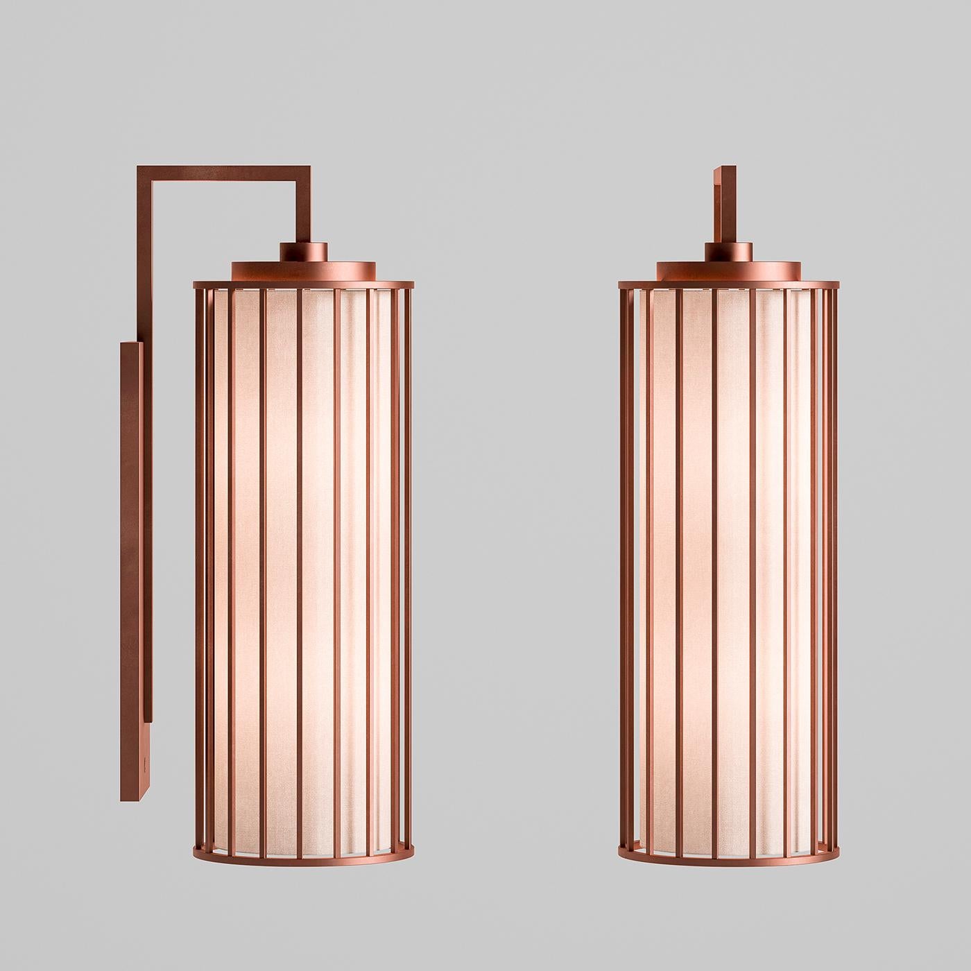 The unique aesthetic and subtle complexity of this singular sconce make it an exceptional statement piece for any modern or midcentury decor. Mounted on the wall with a slender rectangular metal plate, this exquisite lantern hangs from an angled arm