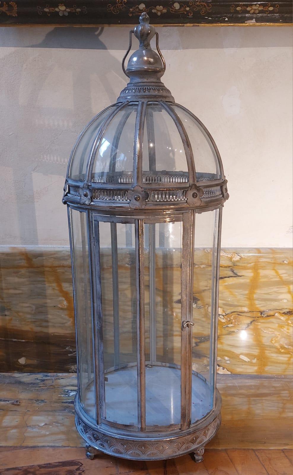 The curved glass and embossed metal lantern can be traced back to the 19th century and is of Russian manufacture.

At the bottom it has four small feet that allow it to rest on the ground. The circular ring at the base has floral pattern
