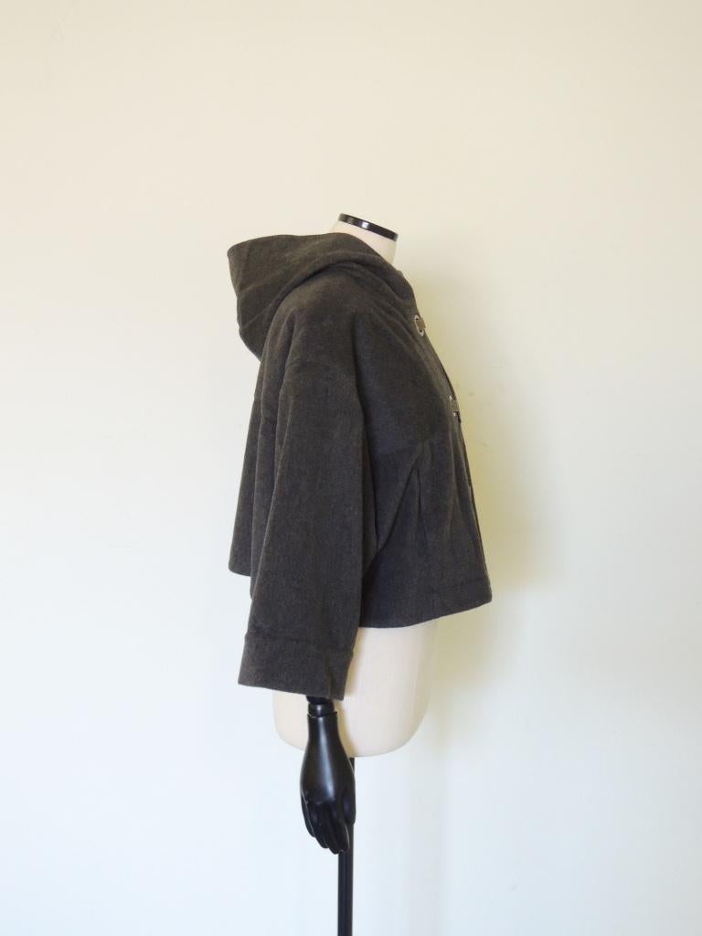 This is a Lanvin cropped, hooded wool jacket/coat, labeled Hiver 2007, with metal ring/clasp closures and two front pockets.

This piece is tagged size 40, 100% wool, made in France.

This is in excellent pre-owned condition with no stains, no