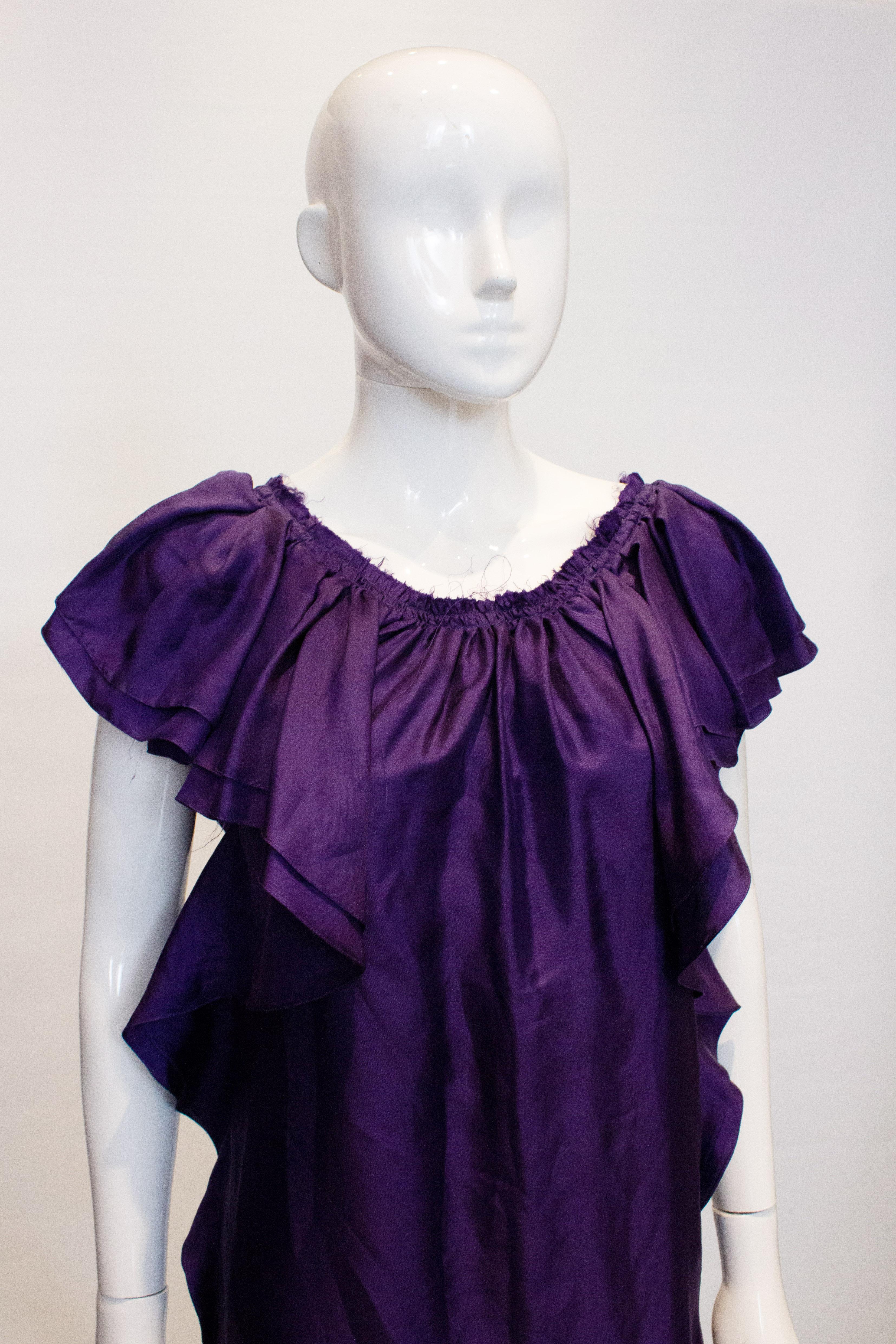 A pretty purple silk dress by Lanvin, Summer 2008. The dress is unworn with clothing tags intact.  It has gathering at the neck and frills around the armholes and along the side. There is a 3''border at the hem, and it is marked size 38.