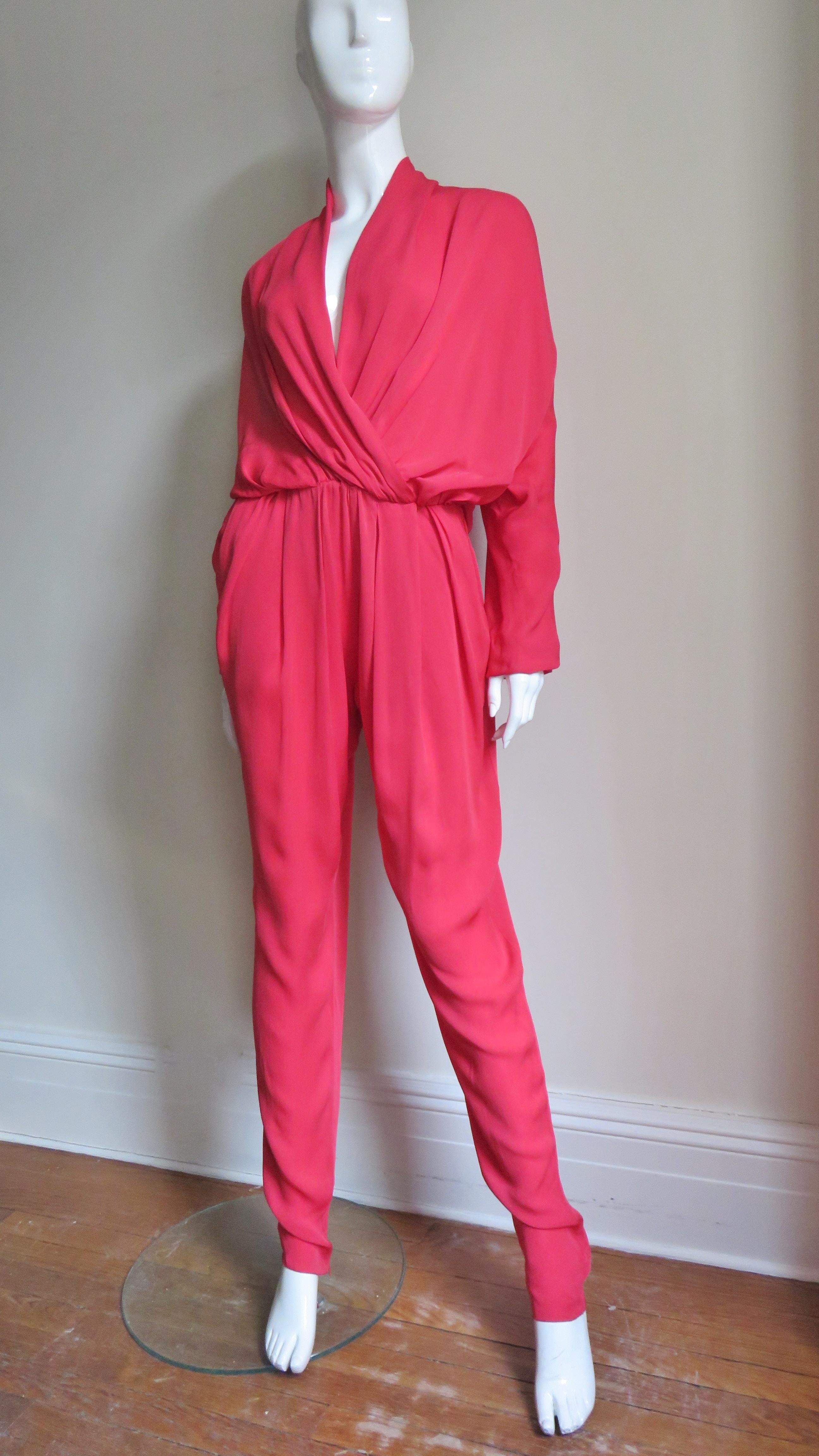 A fabulous red jumpsuit from Lanvin S/S 2014 collection.  It wraps at the front creating a V neckline and has full dolman sleeves with stretch at the wrists and waist.  The pant legs taper to zippers at the ankles and have side seam hip pockets.  It