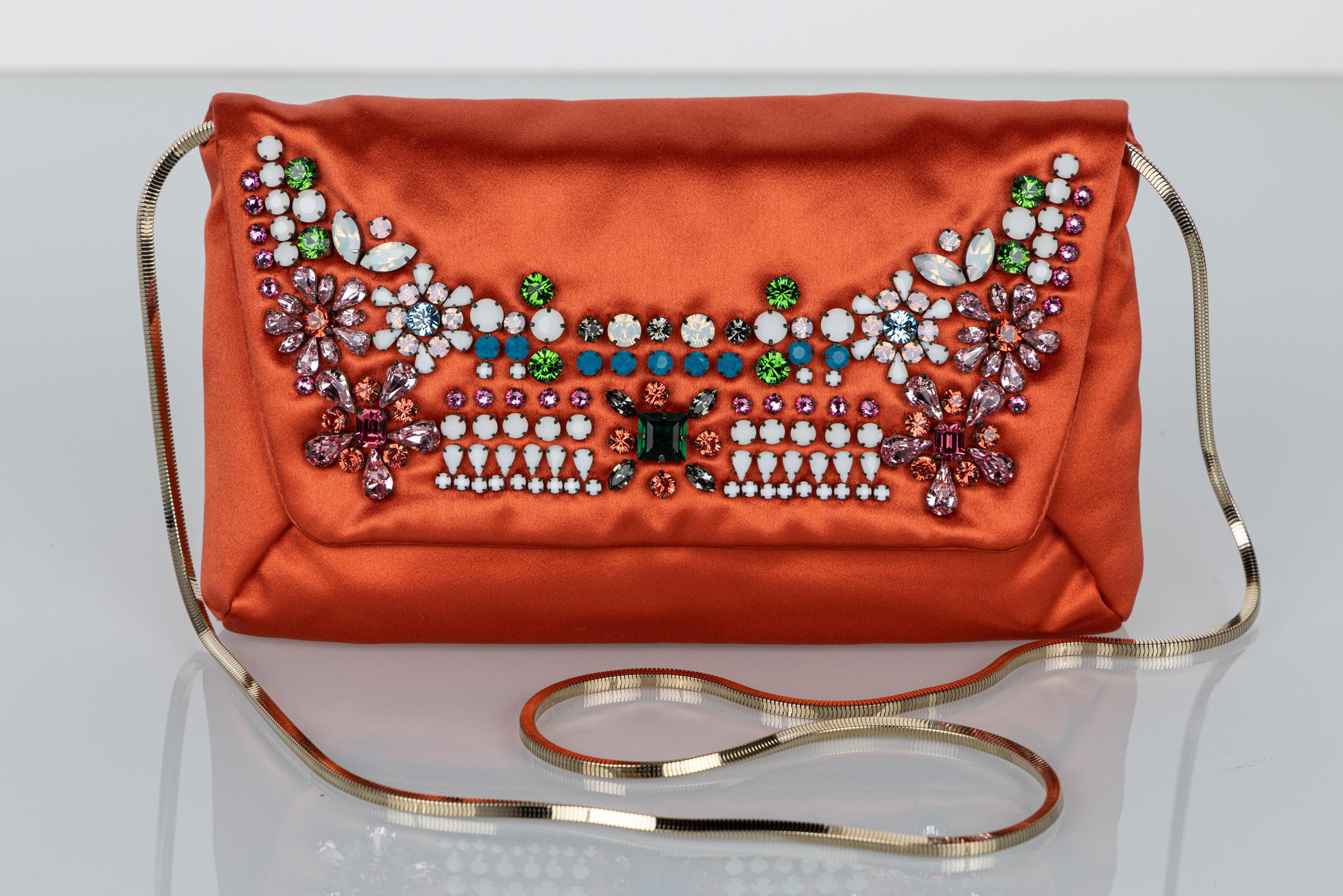 Lanvin Alber Elbaz convertible bag/Clutch. Done in coral orange, the gold sanle chain can be tucked in and used as a clutch.
The flap is embellished with dazzling prong set Swarovski crystals.
Snap closure interior is lined and trimmed with